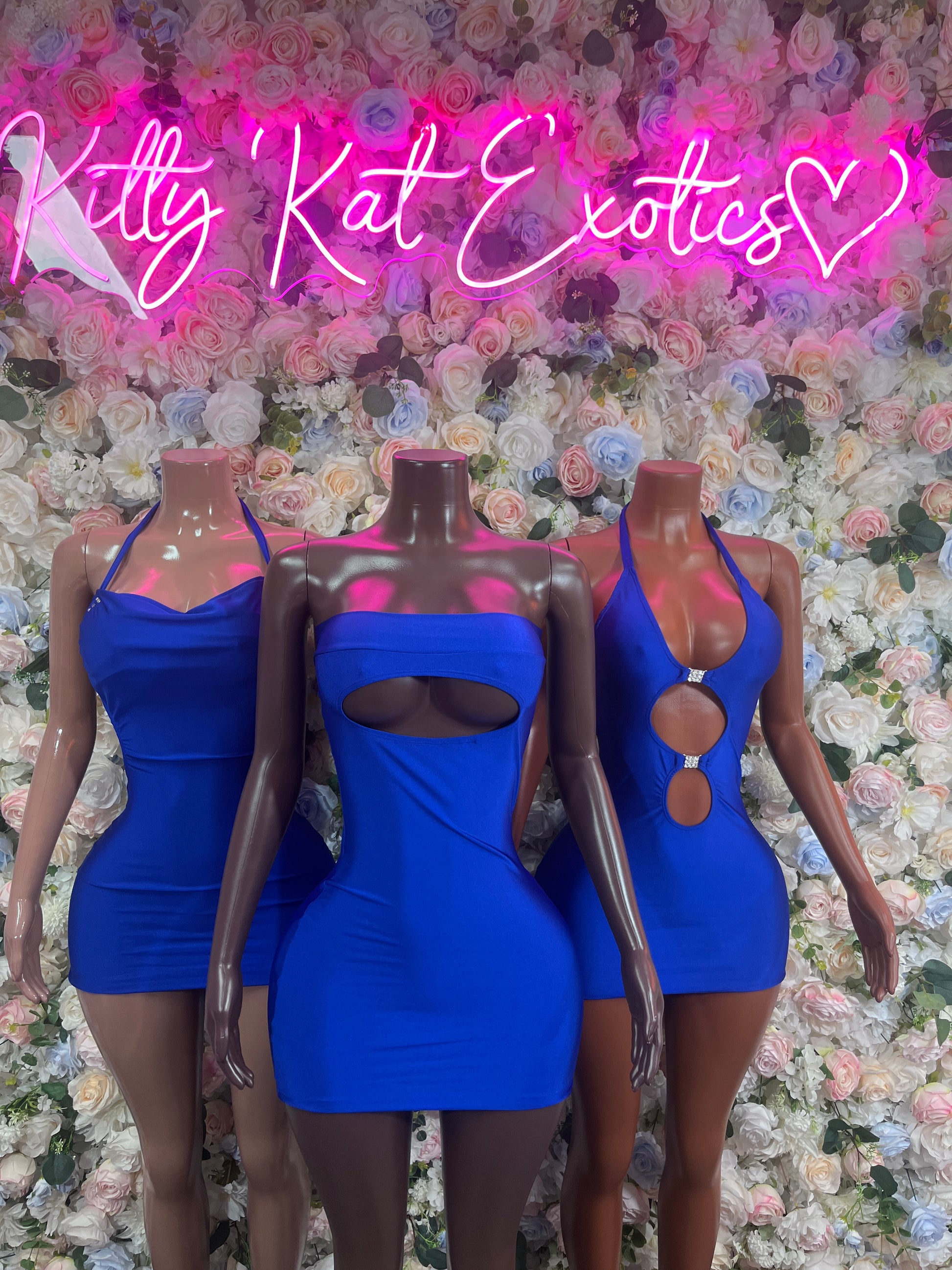 Royal blue mini club dresses on mannequins, halter neckline and oval cutout details