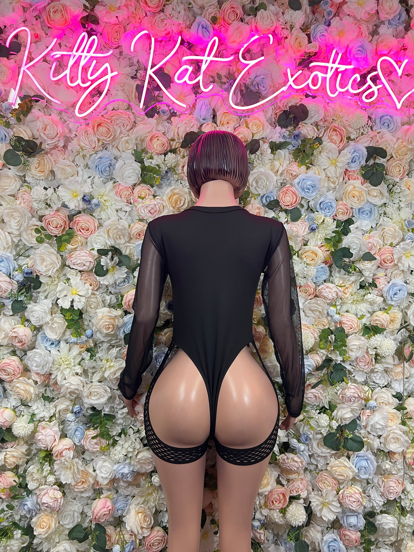 Back view: black long-sleeve sheer bodysuit with lace-up neckline and garter-style thigh straps