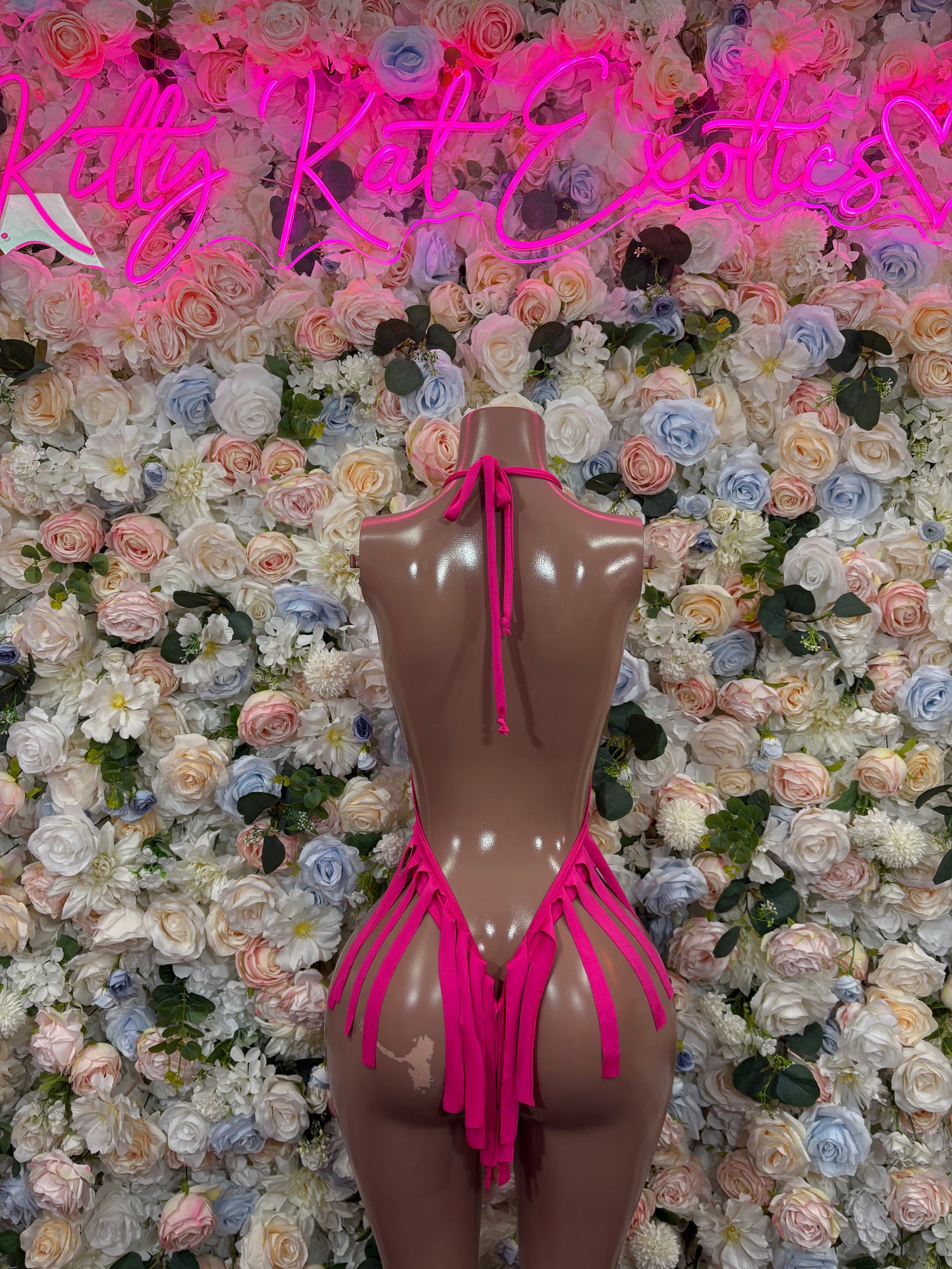Pink bodysuit with open back, thin shoulder straps, and tie details