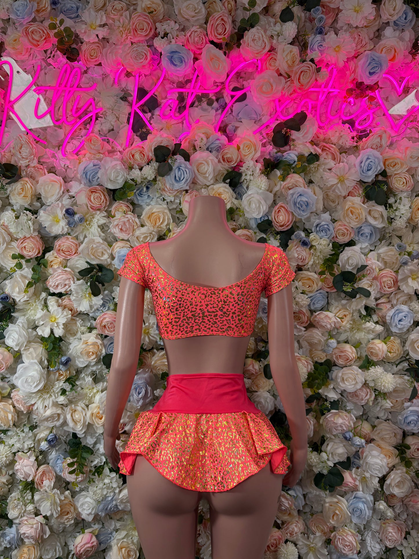 Coral cheetah-print two-piece with off-shoulder top and ruffled mini skirt, back view