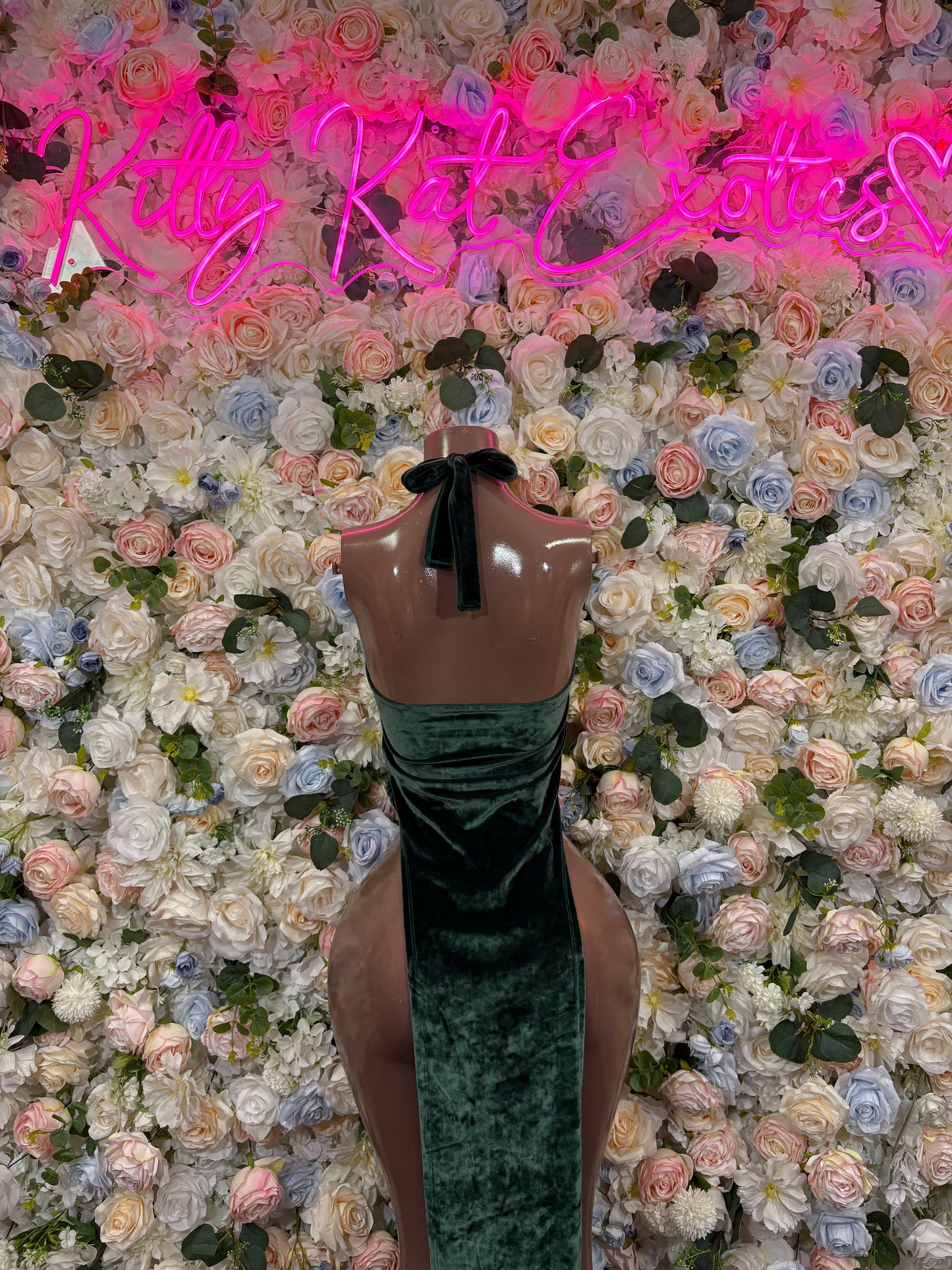 Dark green velvet maxi gown with halter neckline, sleeveless on mannequin