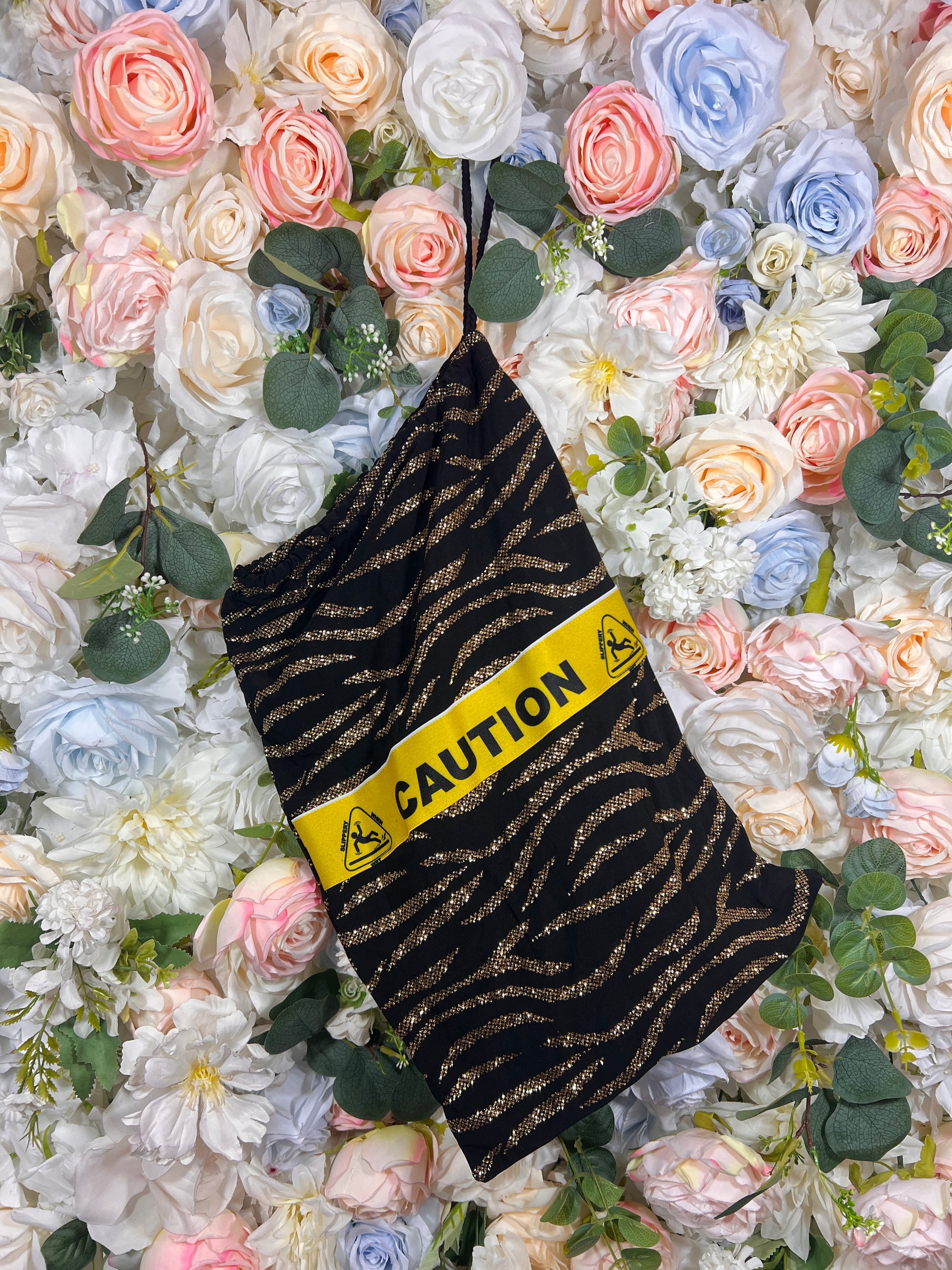 Black glitter money bag with gold wavy pattern and CAUTION warning print