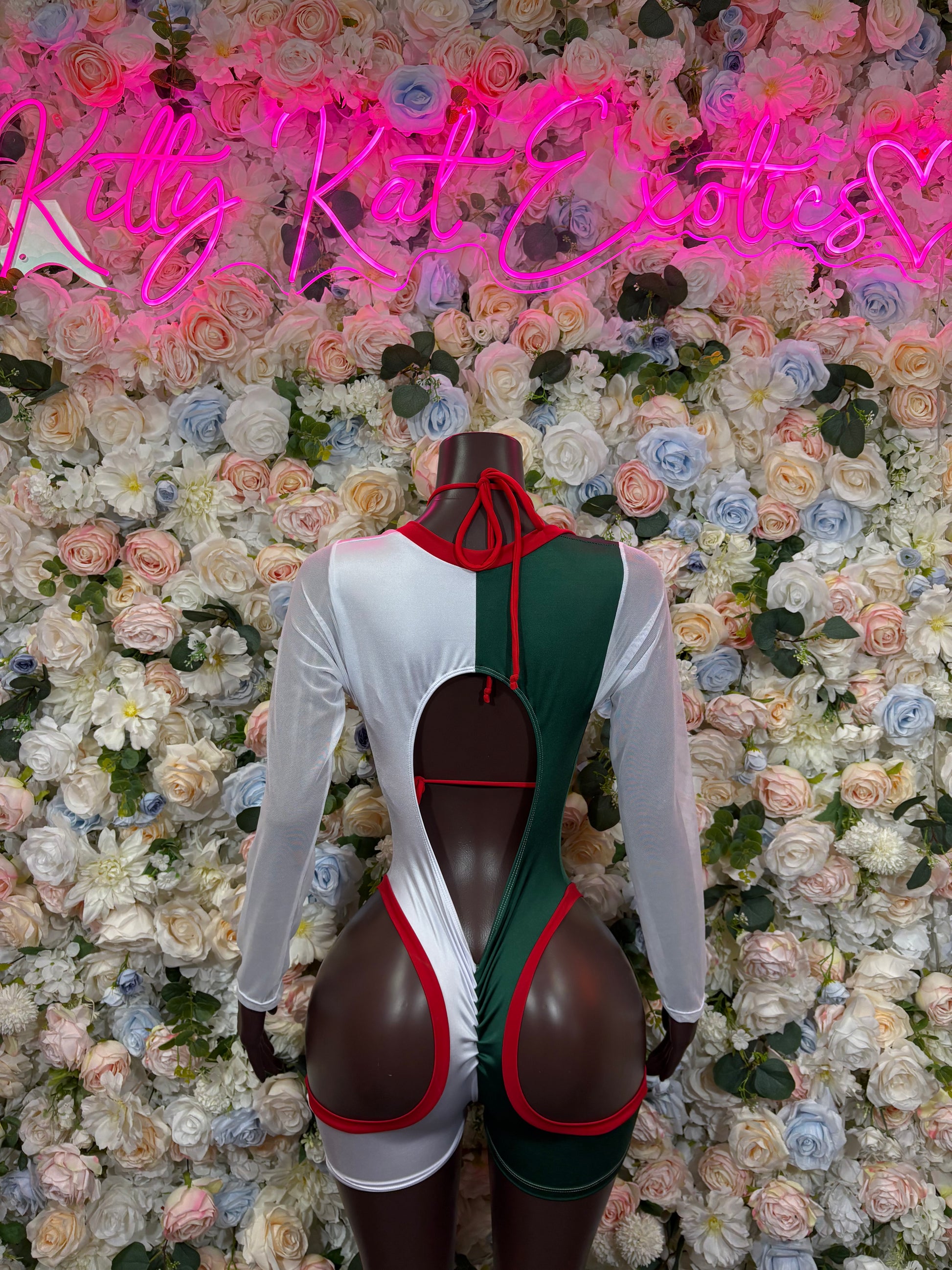 Green, red and white bodysuit back view with long sleeves and red neck tie