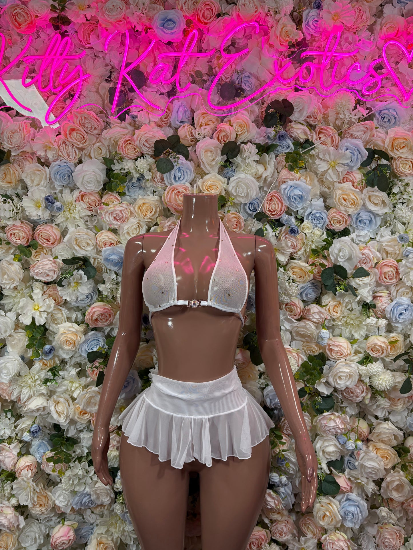 White two-piece mini skirt set with ruched cropped bra and layered pleated skirt