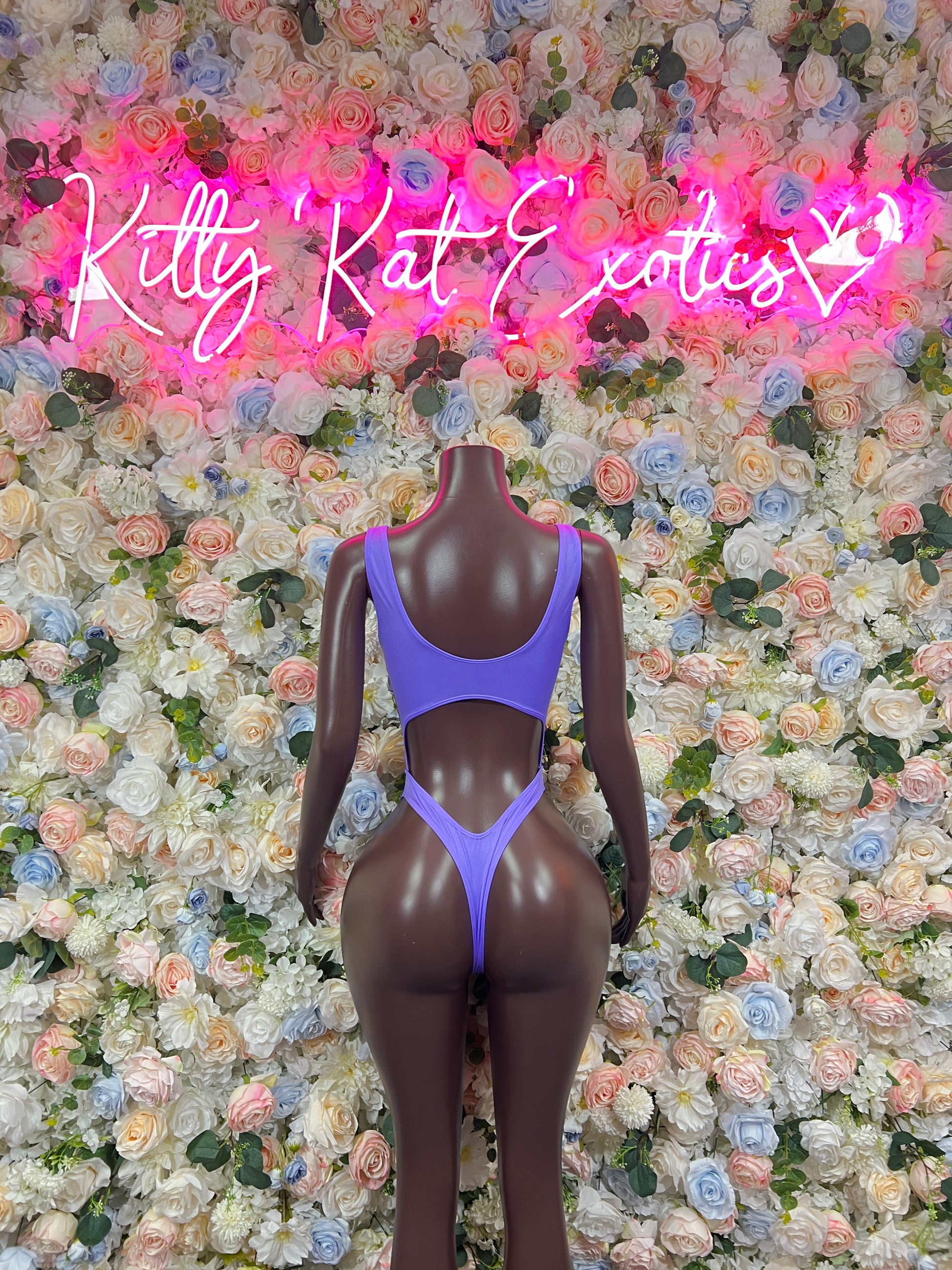 Purple one-piece bodysuit with deep V front and high-cut leg