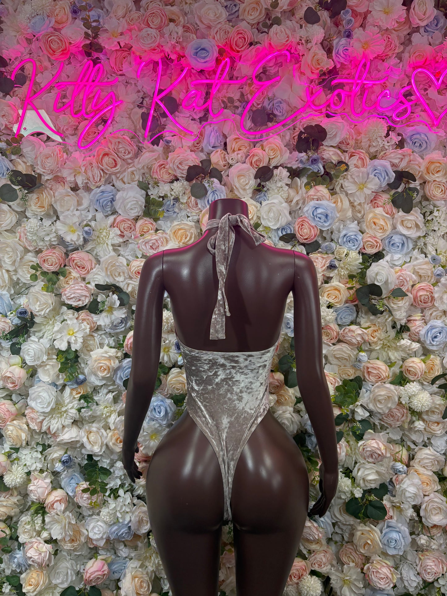 Metallic silver velvet bodysuit with halter neckline, open back, and keyhole chest