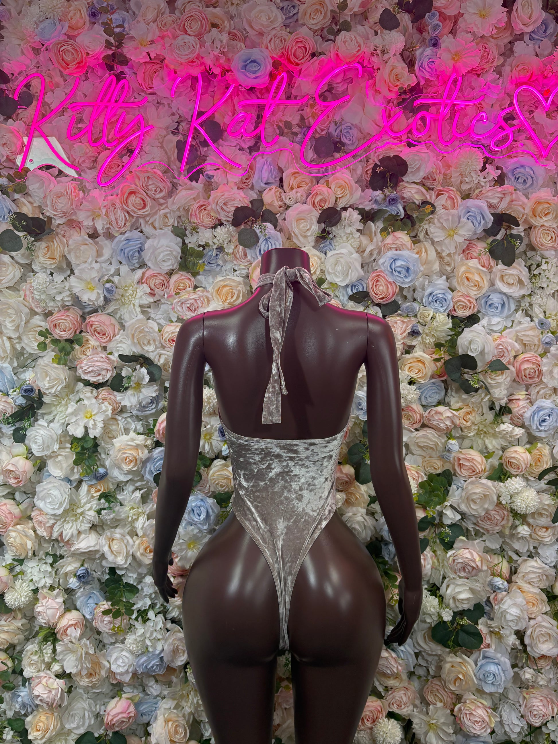 Metallic silver velvet bodysuit with halter neckline, open back, and keyhole chest