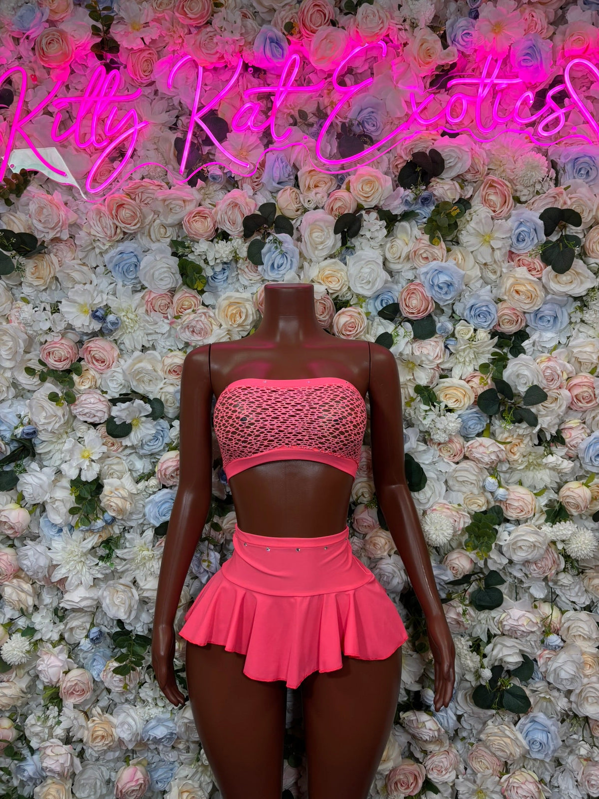 Coral pink bandeau mini skirt set: textured strapless top, ruffled mini skirt
