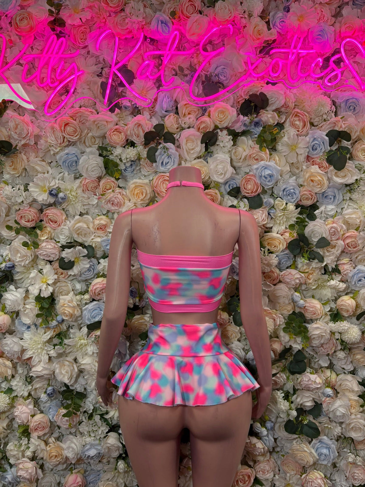 Back view of pink bandeau bikini set with bow and abstract print peplum skirt