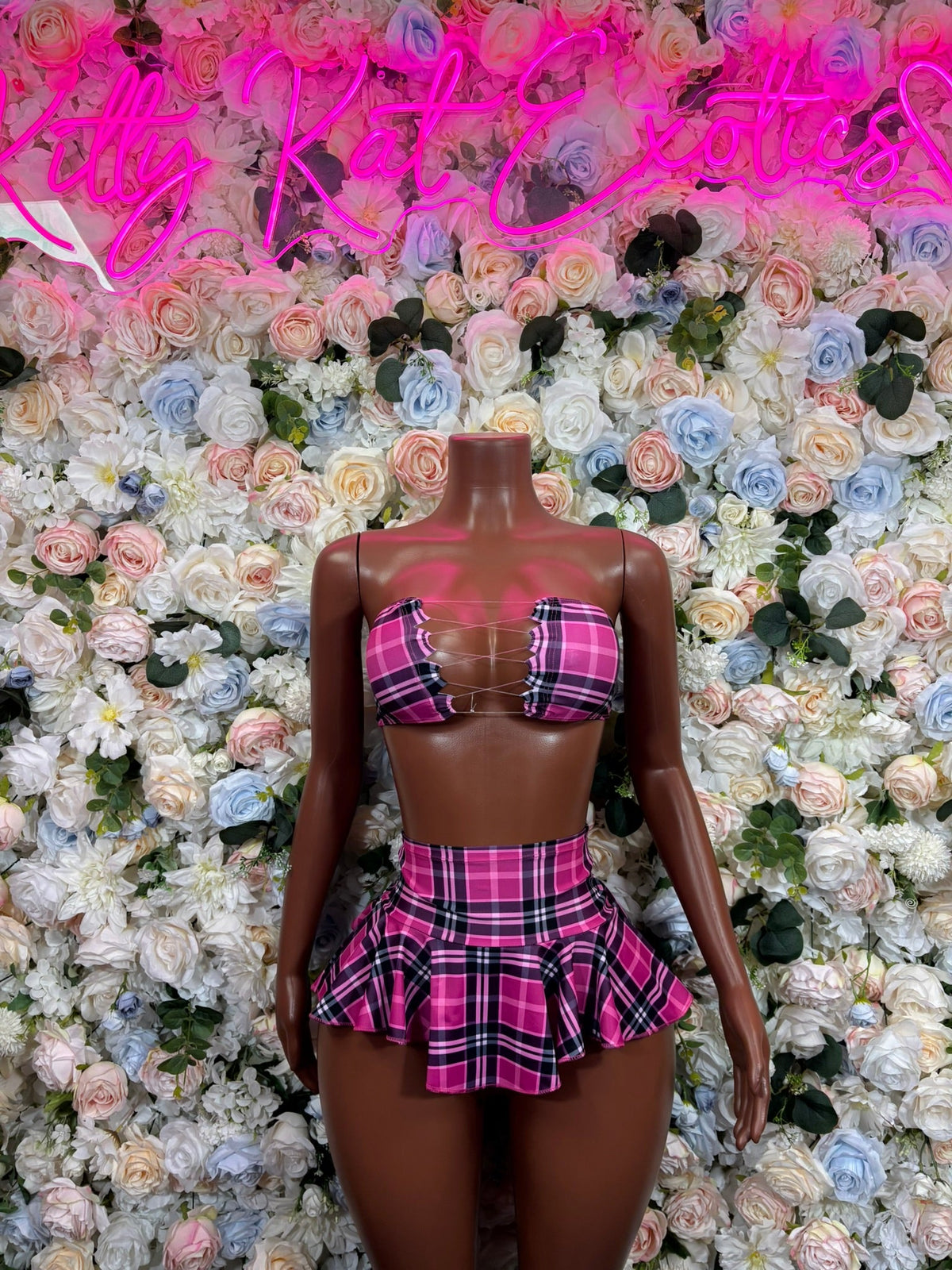 Pink plaid strappy bikini top and flared mini skirt on mannequin, front view