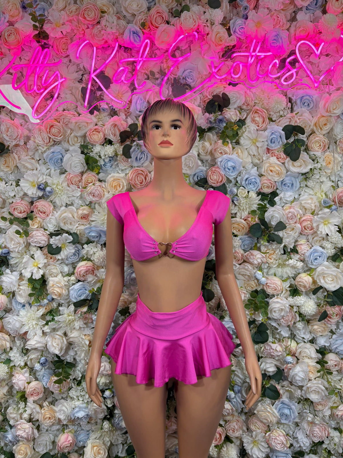 Fuchsia pink crop top with tie-bust and matching flared mini skirt on mannequin