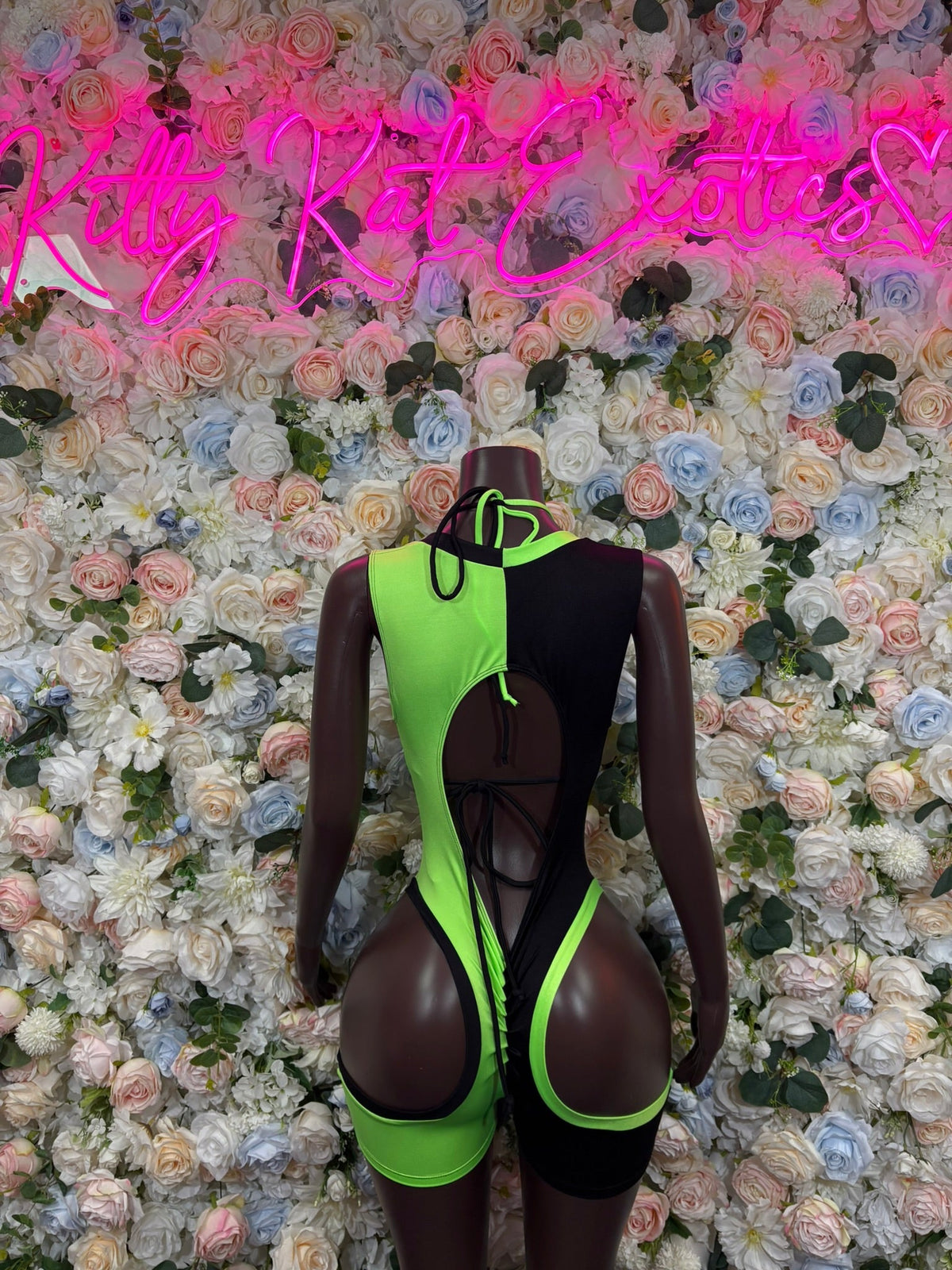 Black and neon green cutout back romper with vertical lace-up detail