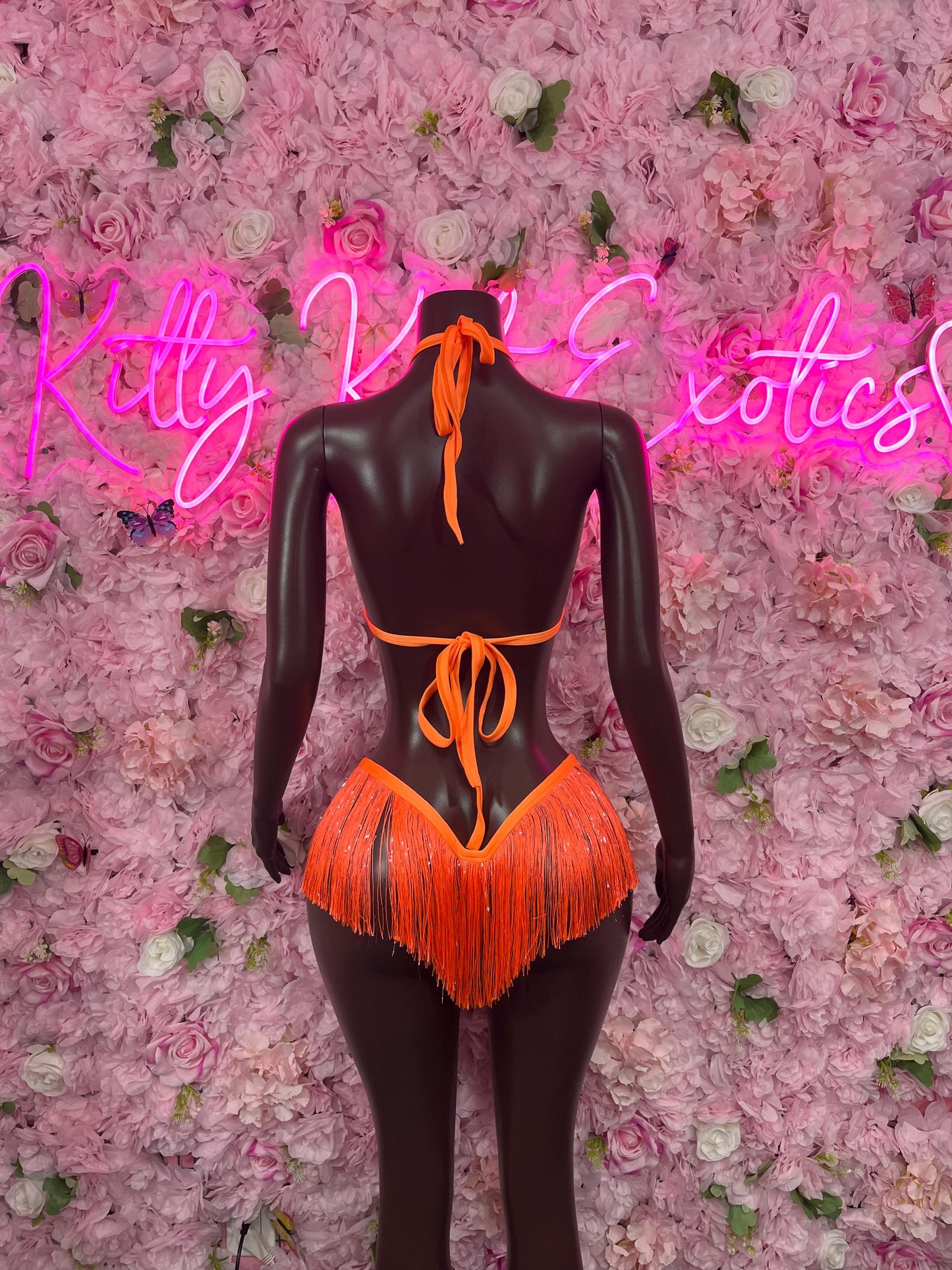 Two-piece orange fringe bikini back view on mannequin, tied strings and V-cut