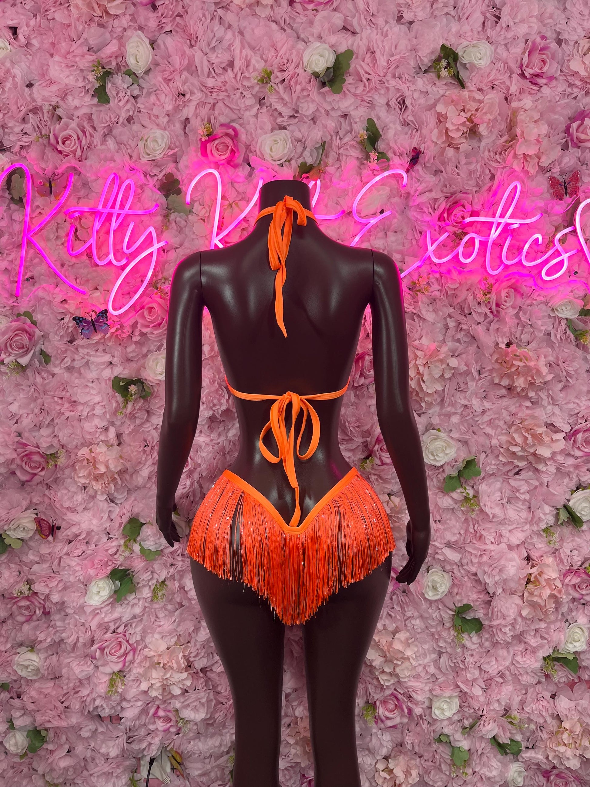 Two-piece orange fringe bikini back view on mannequin, tied strings and V-cut