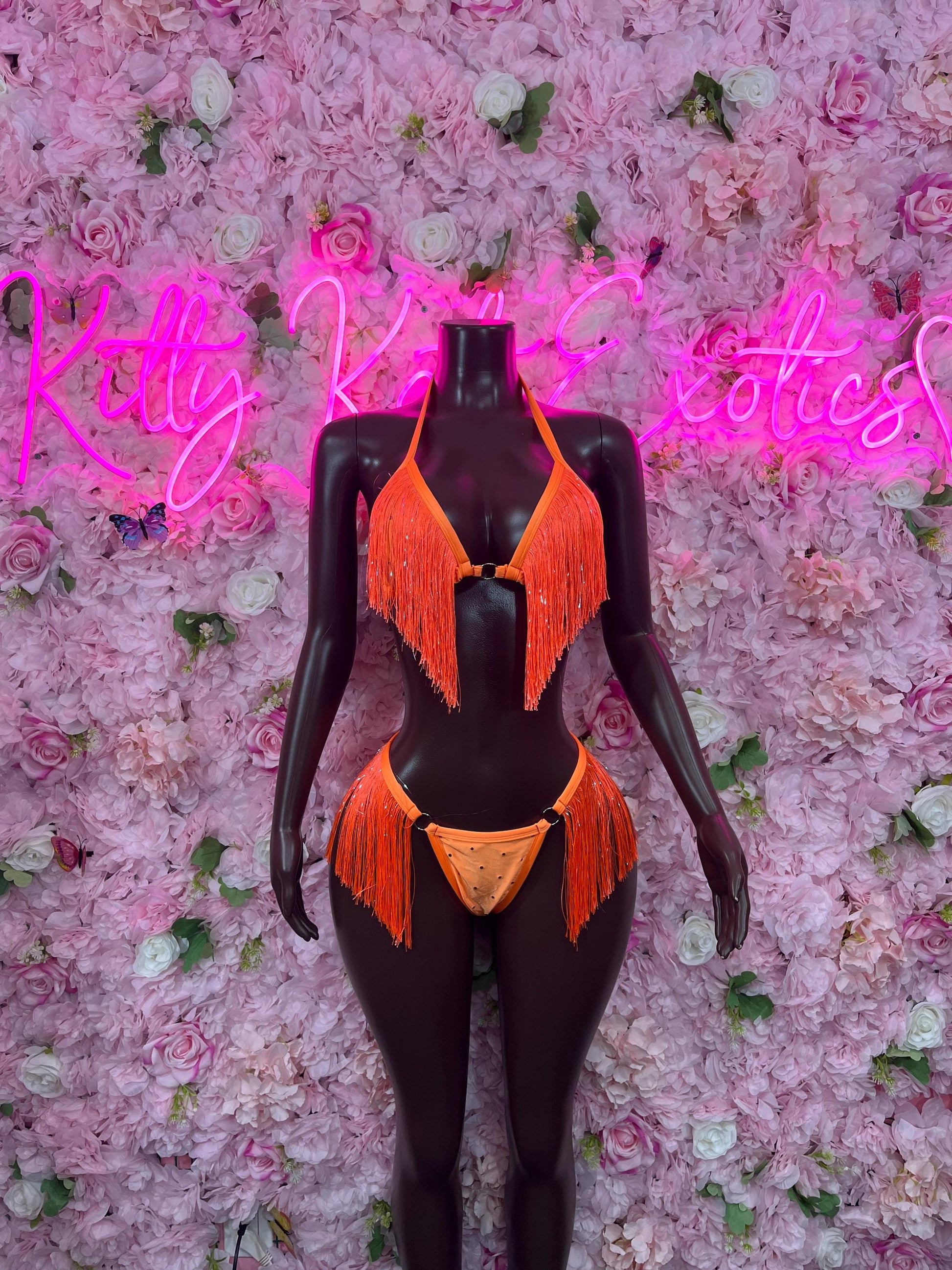 Two-piece orange fringe bikini on mannequin, V-neck top and thong bottoms