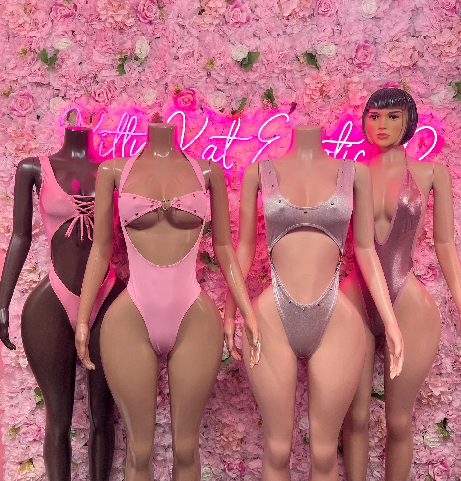 Three one-piece dance bodysuits in dark, pink, and silver tones with V fronts