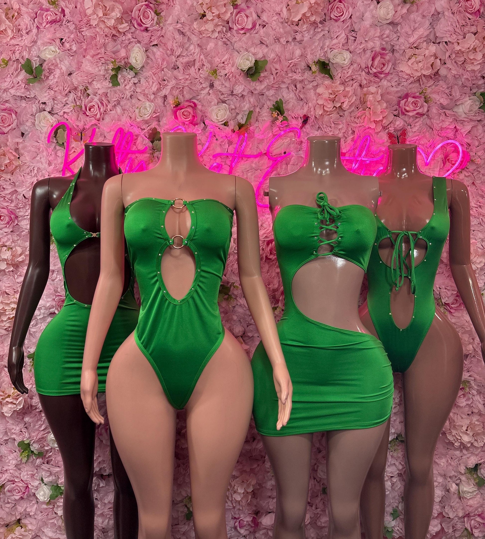 Green one-piece dress with keyhole cutout bodice, ruched mini skirt, and black accents