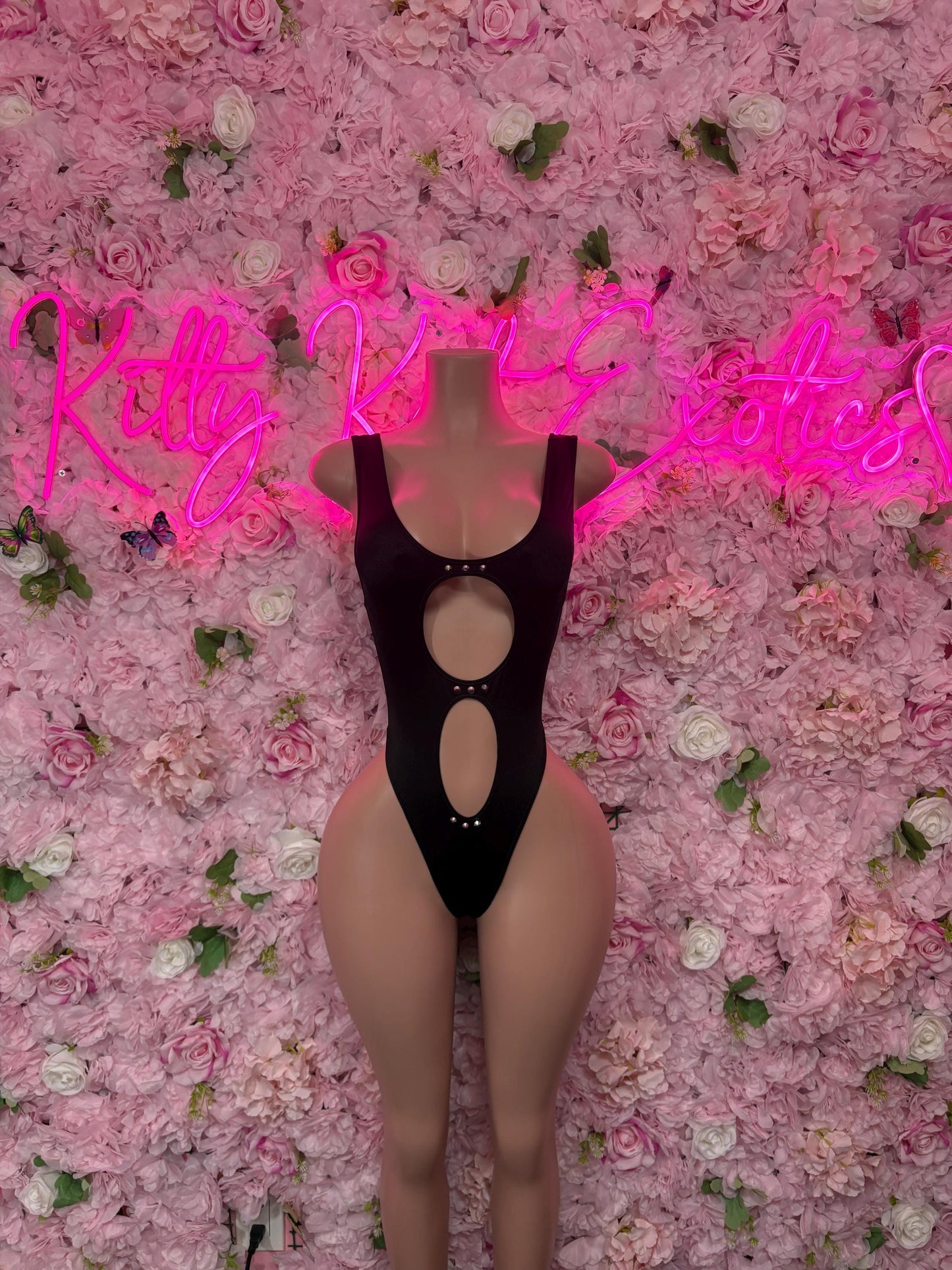 Black one-piece performance bodysuit with halter straps and vertical oval cutouts