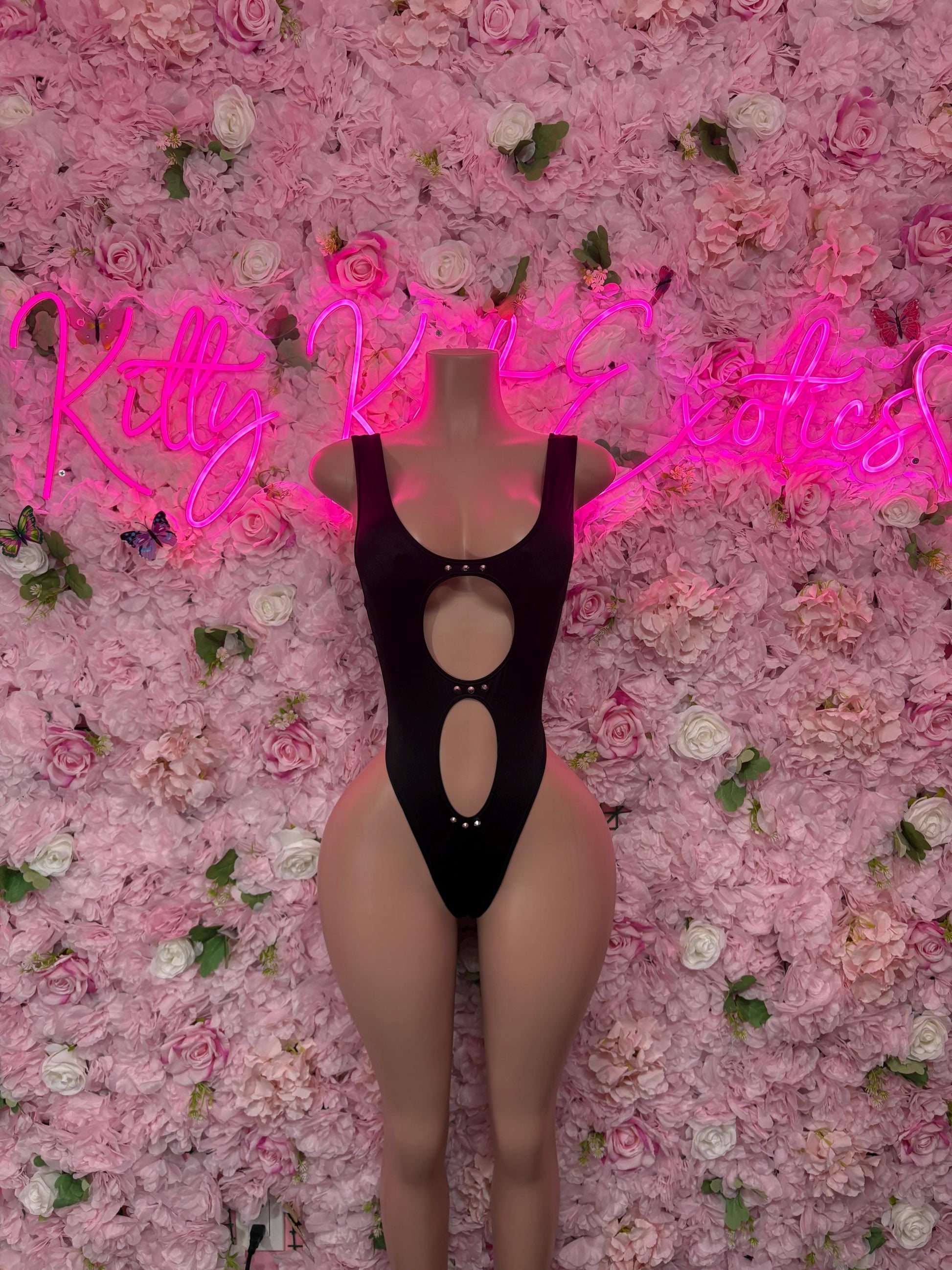 Black one-piece performance bodysuit with halter straps and vertical oval cutouts