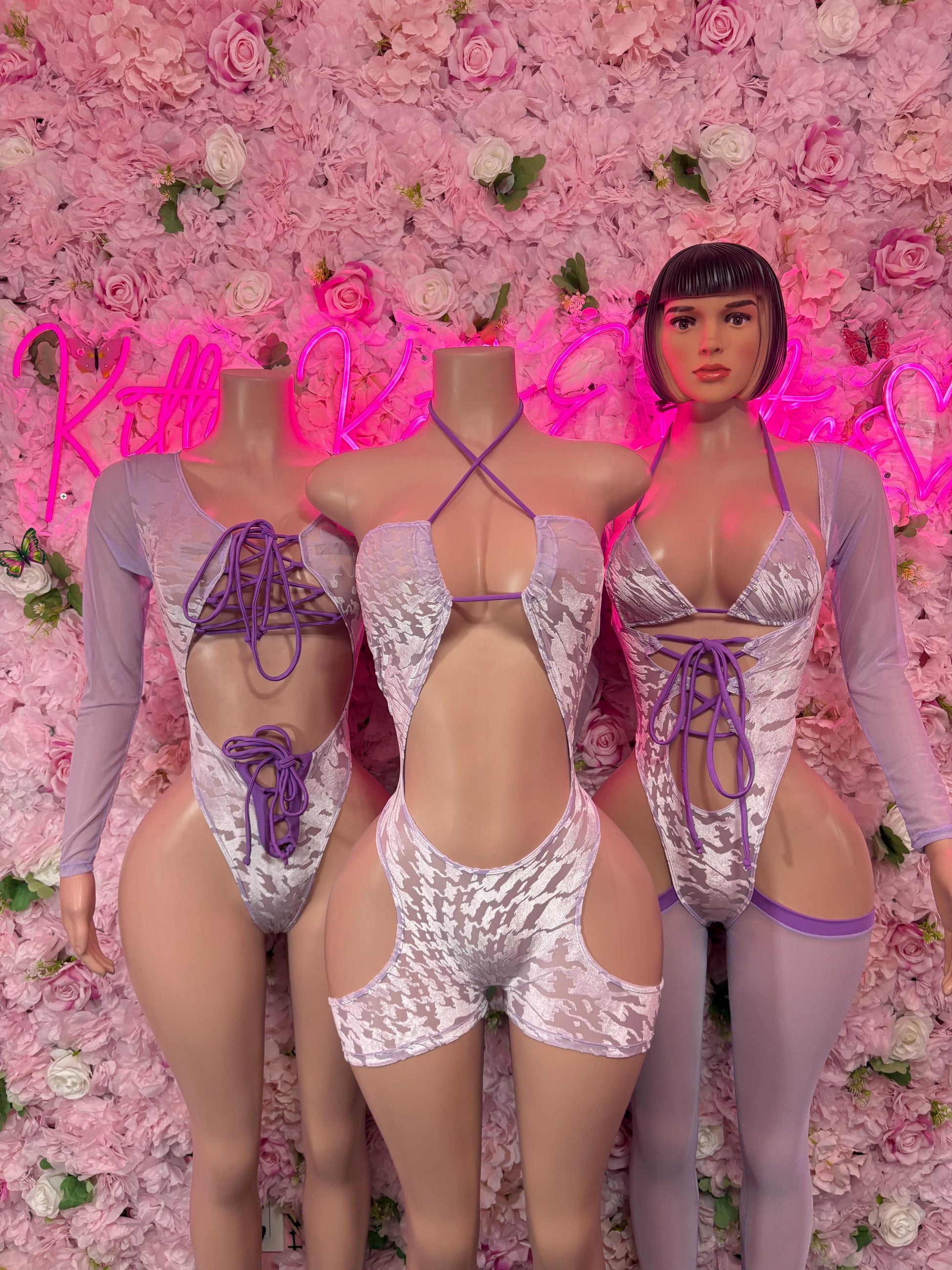 One-piece bodysuit with lace-up details, long sleeves, and purple trim