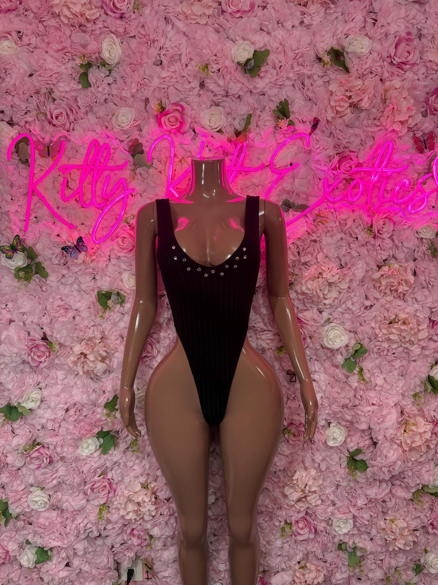 Black one-piece bodysuit with deep V neckline and rhinestone trim, sleeveless