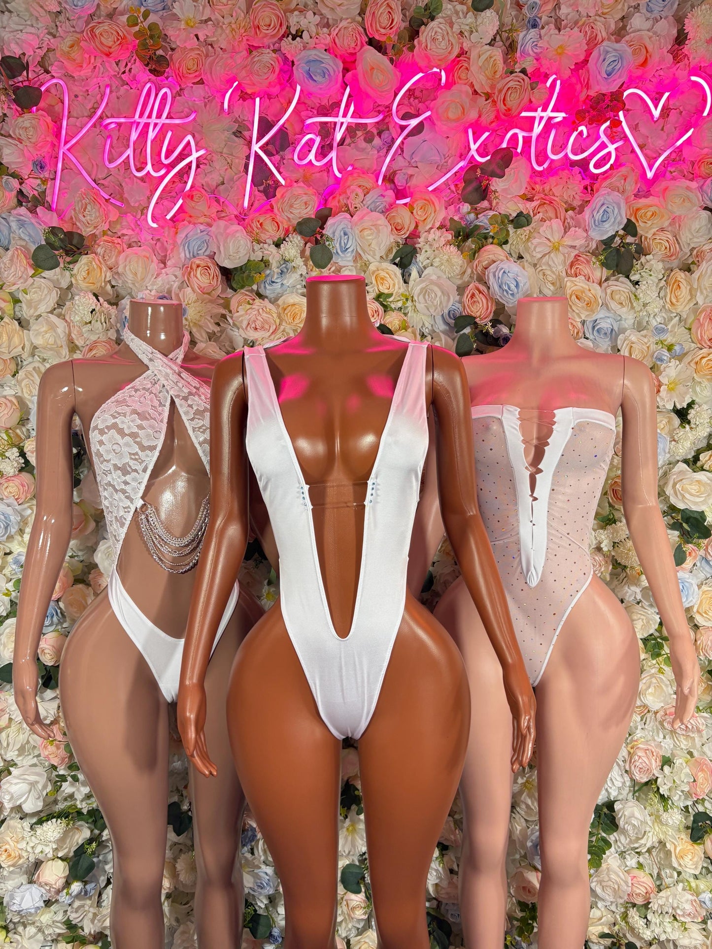 White festival bodysuit on three mannequins with V-neck and chain detail