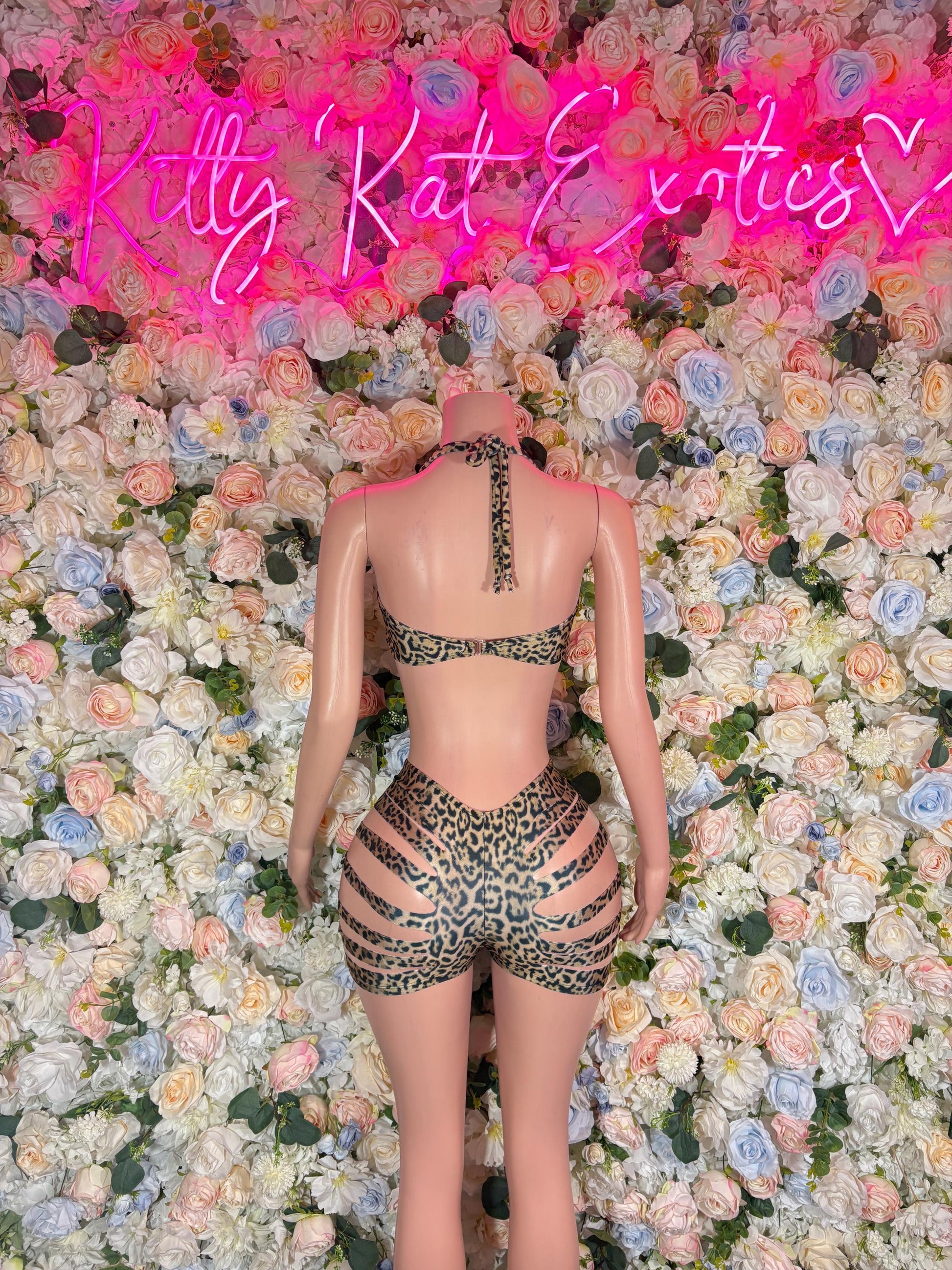 Back view of leopard-print bodysuit with vertical strap detail and cutouts