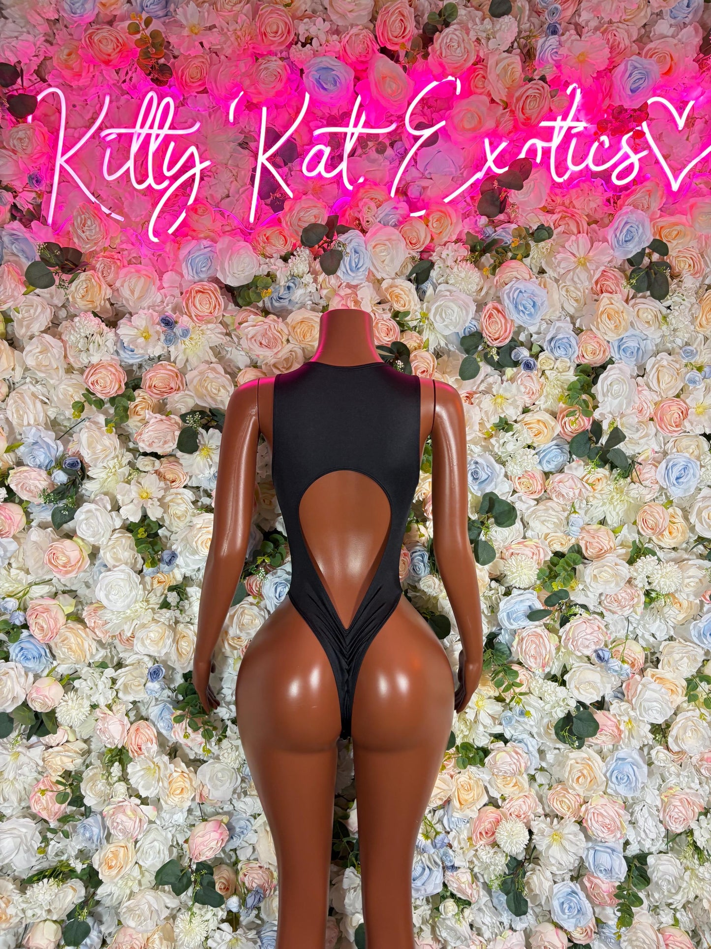 Dark one-piece bodysuit with open back cutout, back view
