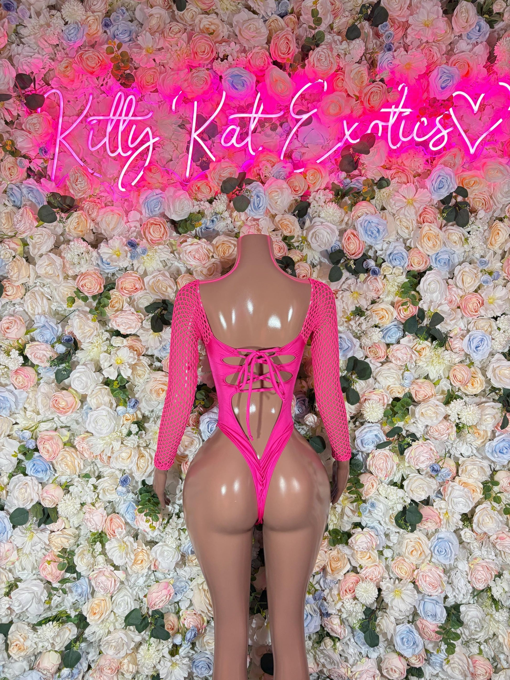 Pink lace-up backless bodysuit with sheer long sleeves and center back cutout