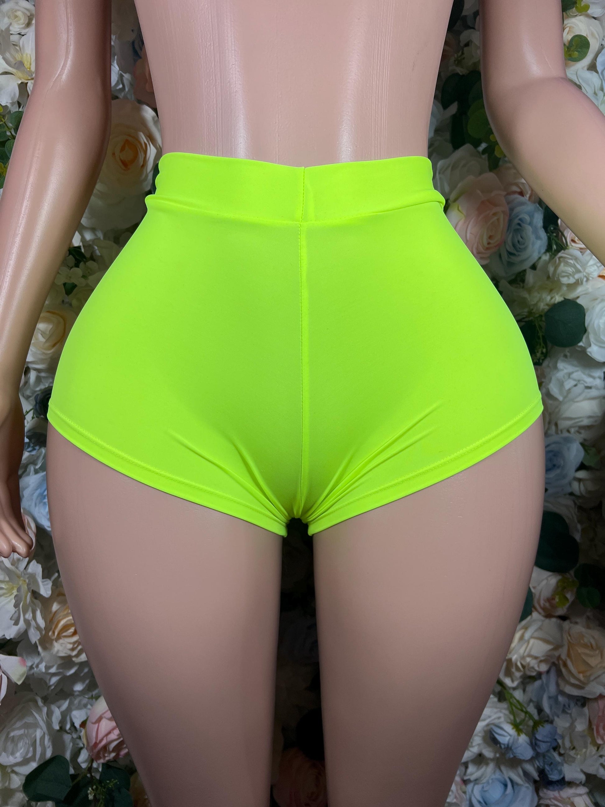 Neon green high-waisted shorts with smooth front and curved hem