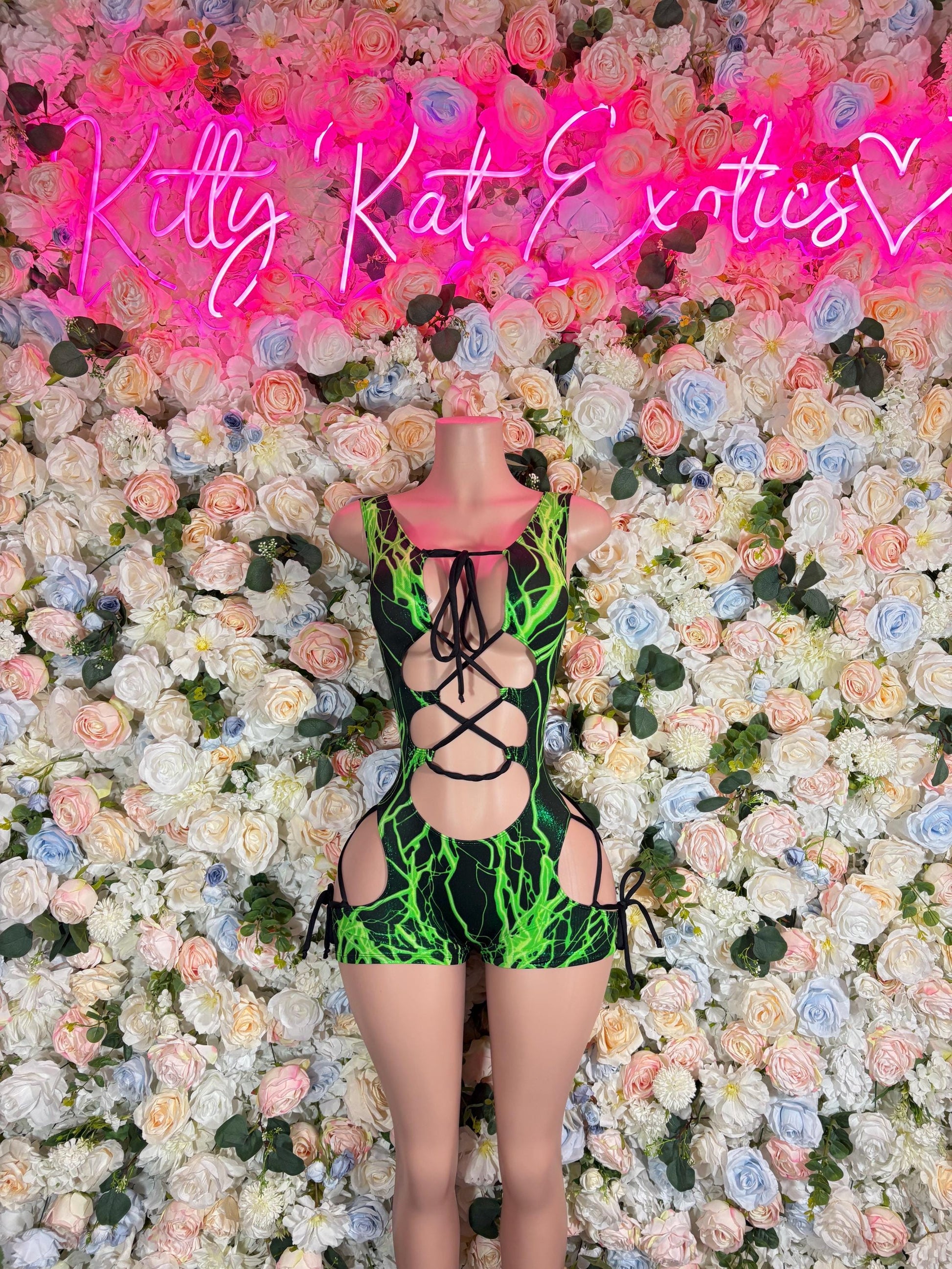 Green electric one-piece bodysuit with front lace-up and midriff cutouts.