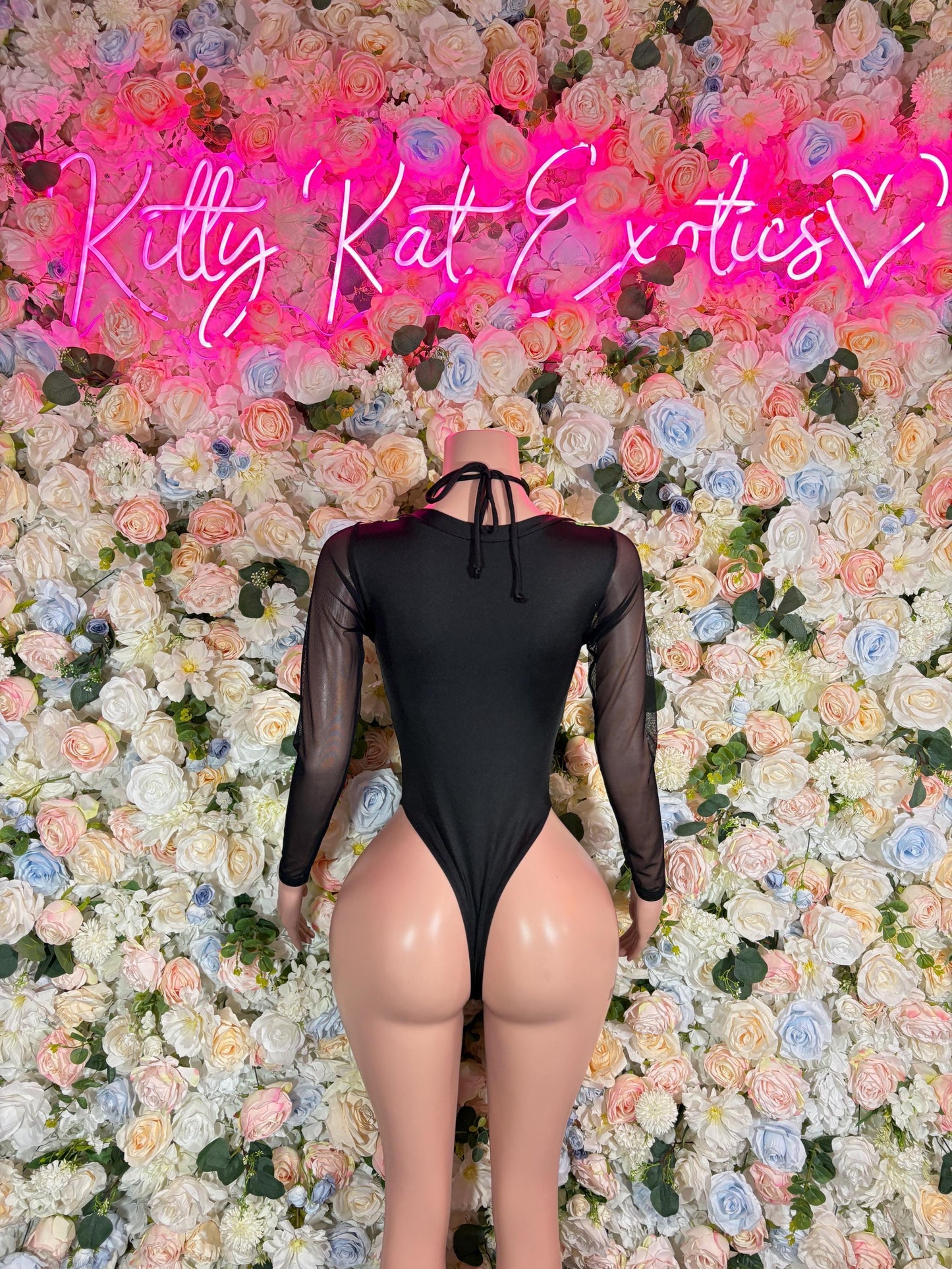 Black long-sleeve one-piece bodysuit with neon green electric-style front; sheer back