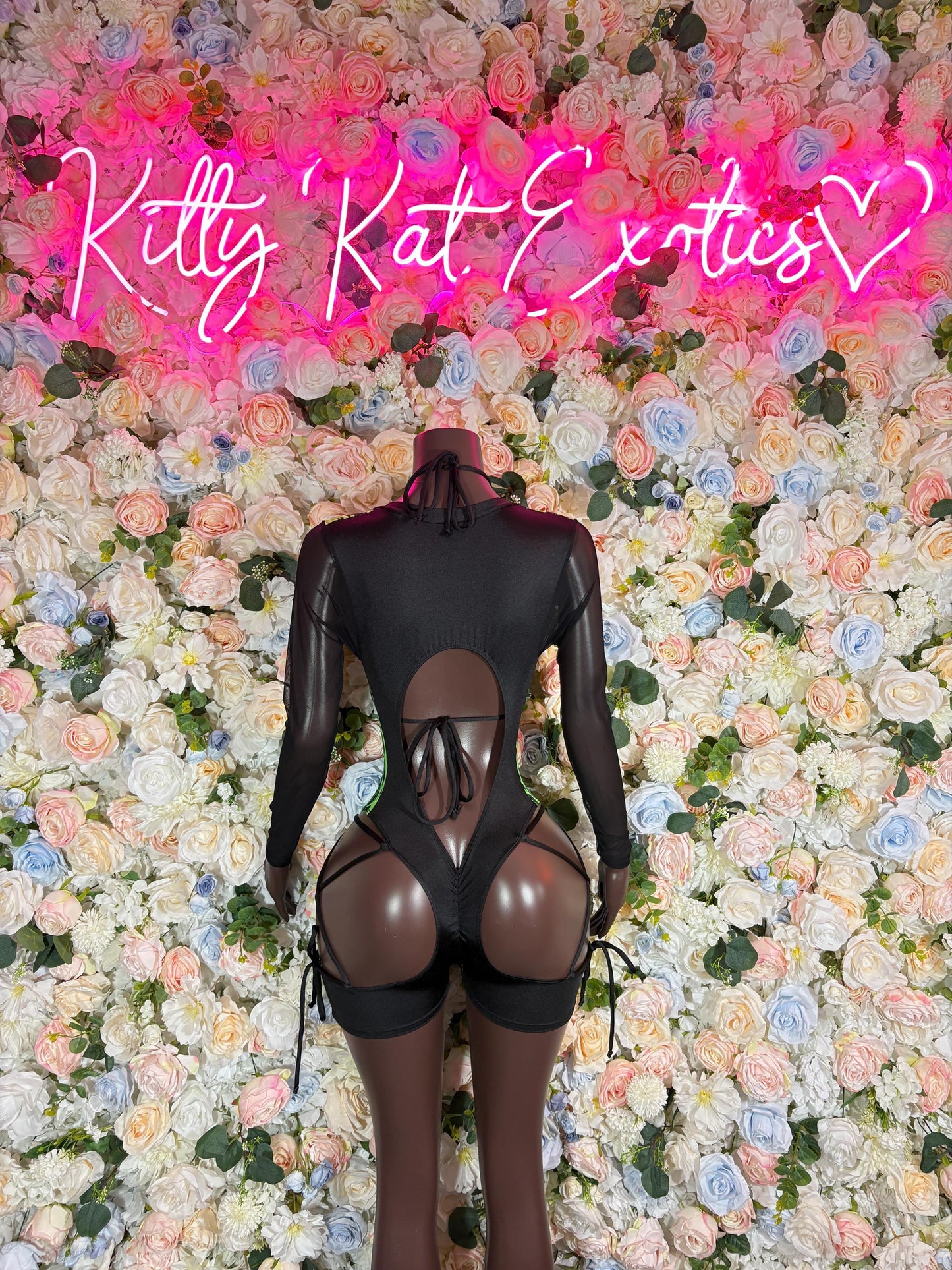 Black one-piece bodysuit with sheer mesh back and neon green graphic lines