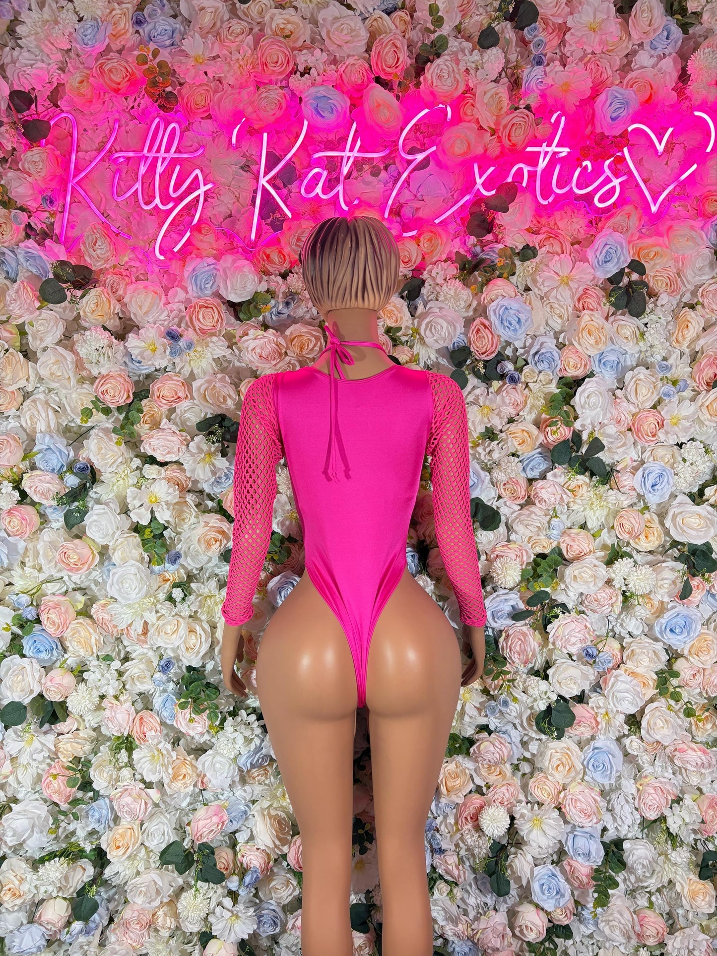Pink one-piece bodysuit with long mesh sleeves, lace-up back, thong cut