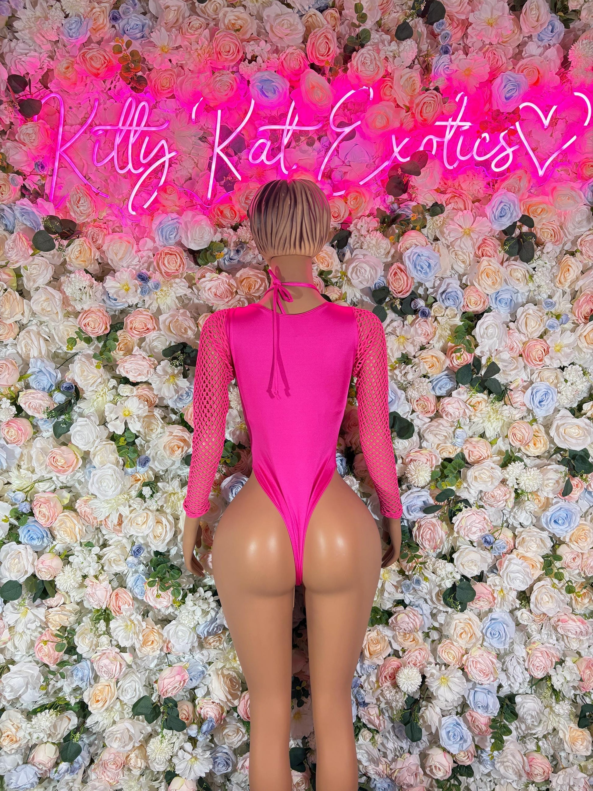 Pink one-piece bodysuit with long mesh sleeves, lace-up back, thong cut