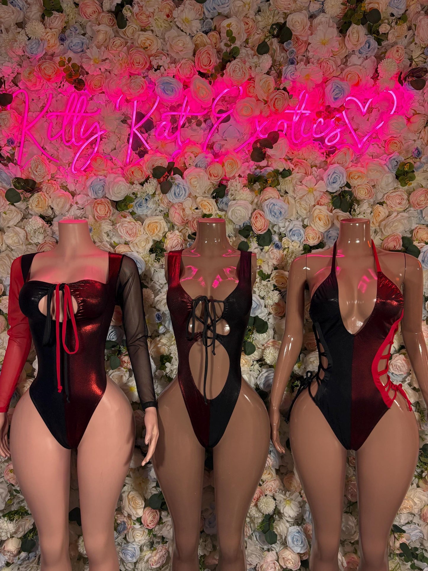 Long-sleeve black and red bodysuit with lace-up cutouts, shown on three mannequins