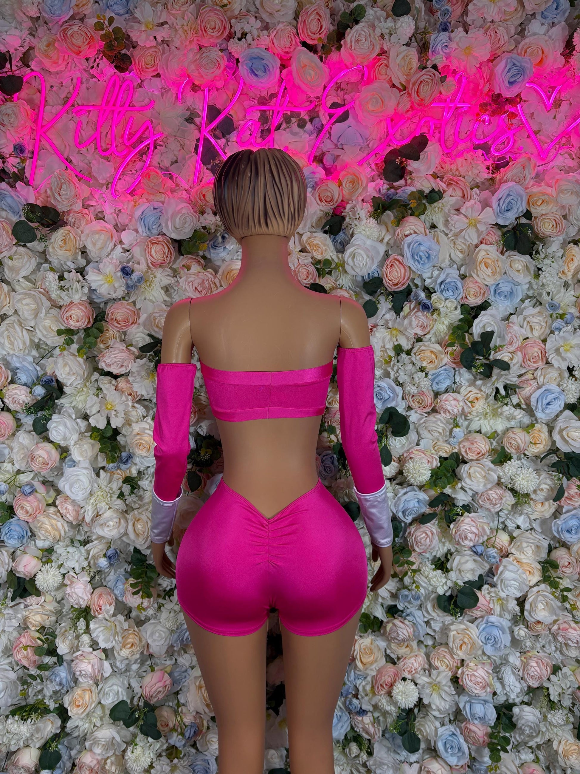 Pink bandeau crop top and high-waist shorts with long pink cuffs, back view
