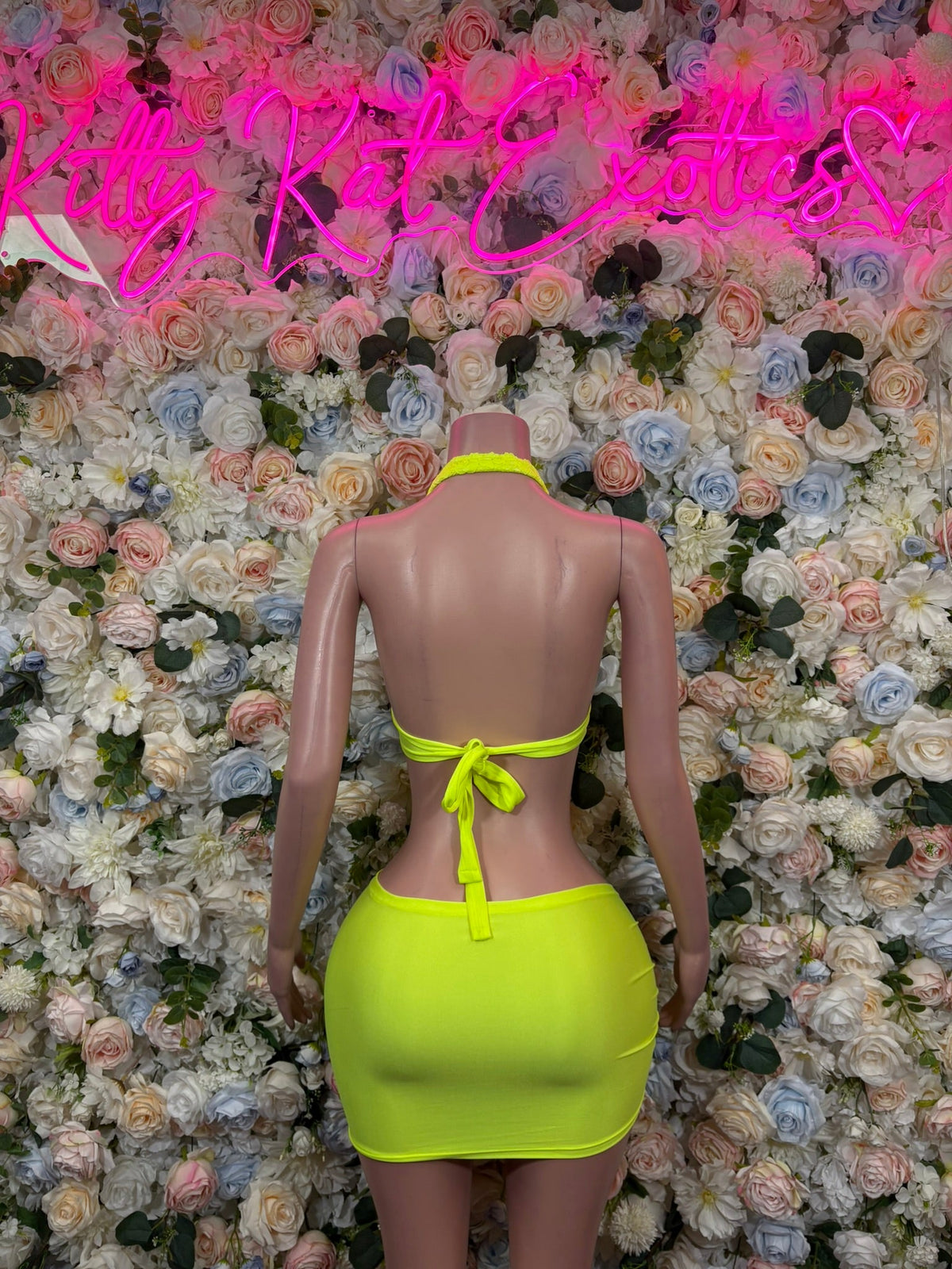 Neon yellow lace halter top with back tie and mini skirt, back view with center strings