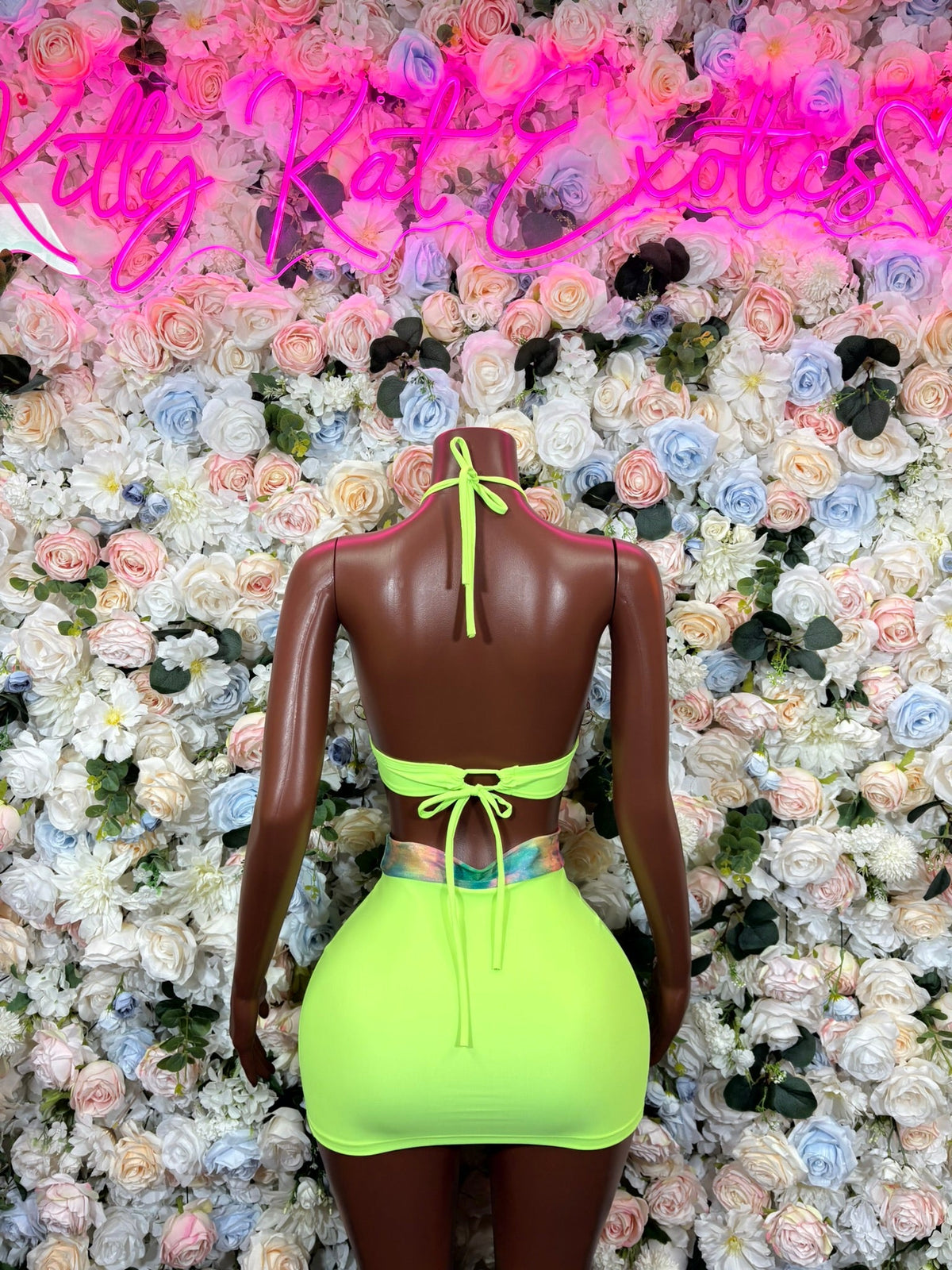Lime green halter crop top and high waist mini skirt two-piece outfit on mannequin