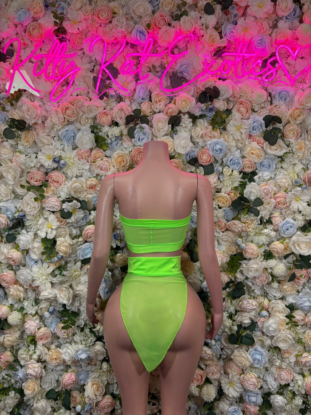 Neon green back view: strapless bandeau crop top and pointed wrap mini skirt
