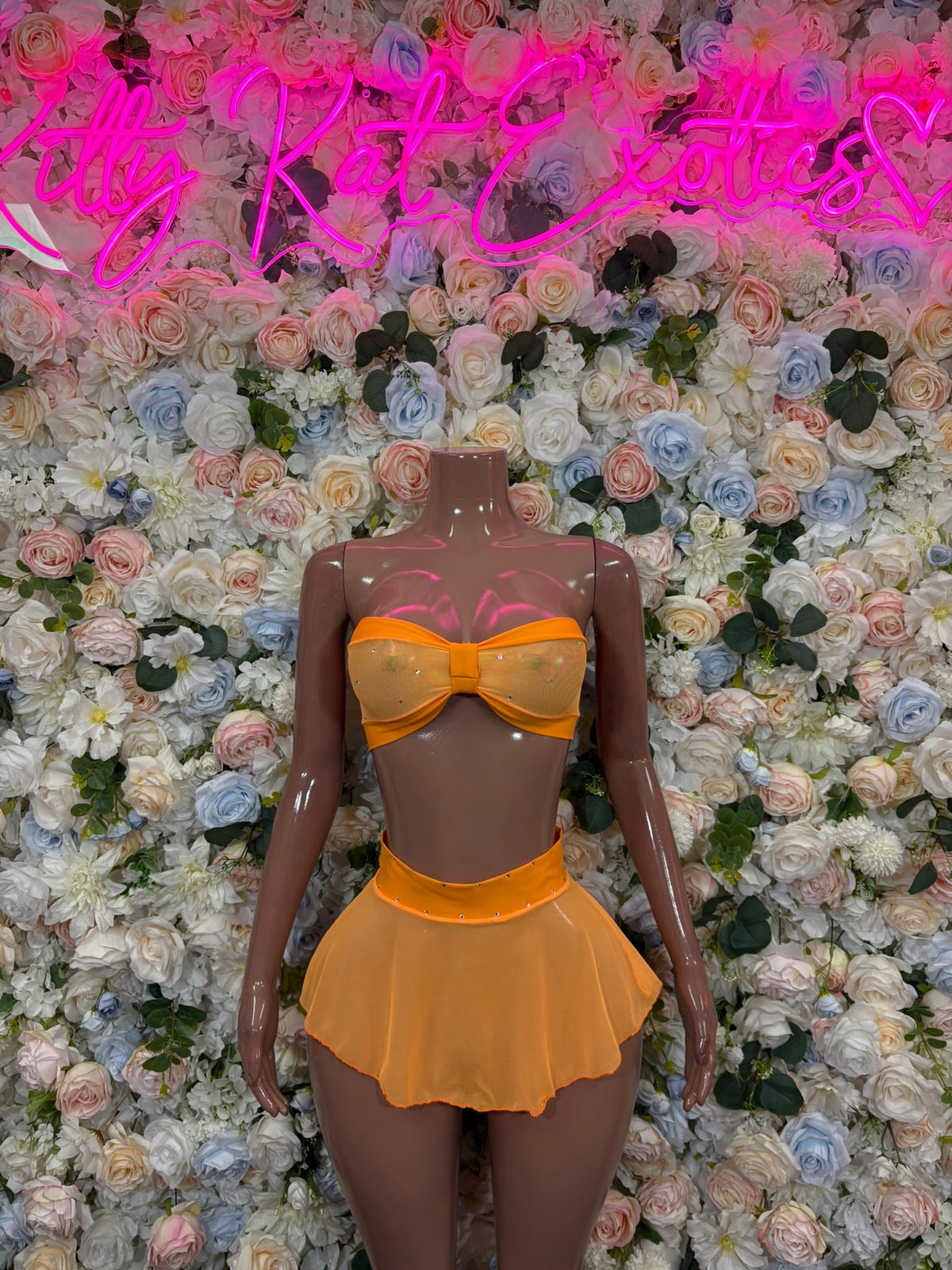 Golden yellow bandeau and flared mini skirt set with bow detail on mannequin
