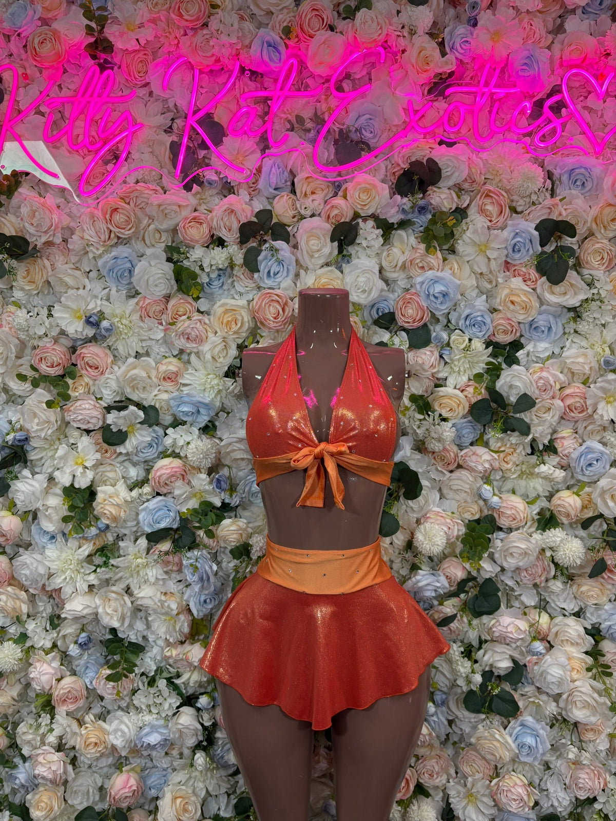Orange tie-front halter top with bow and flared mini skirt, front view