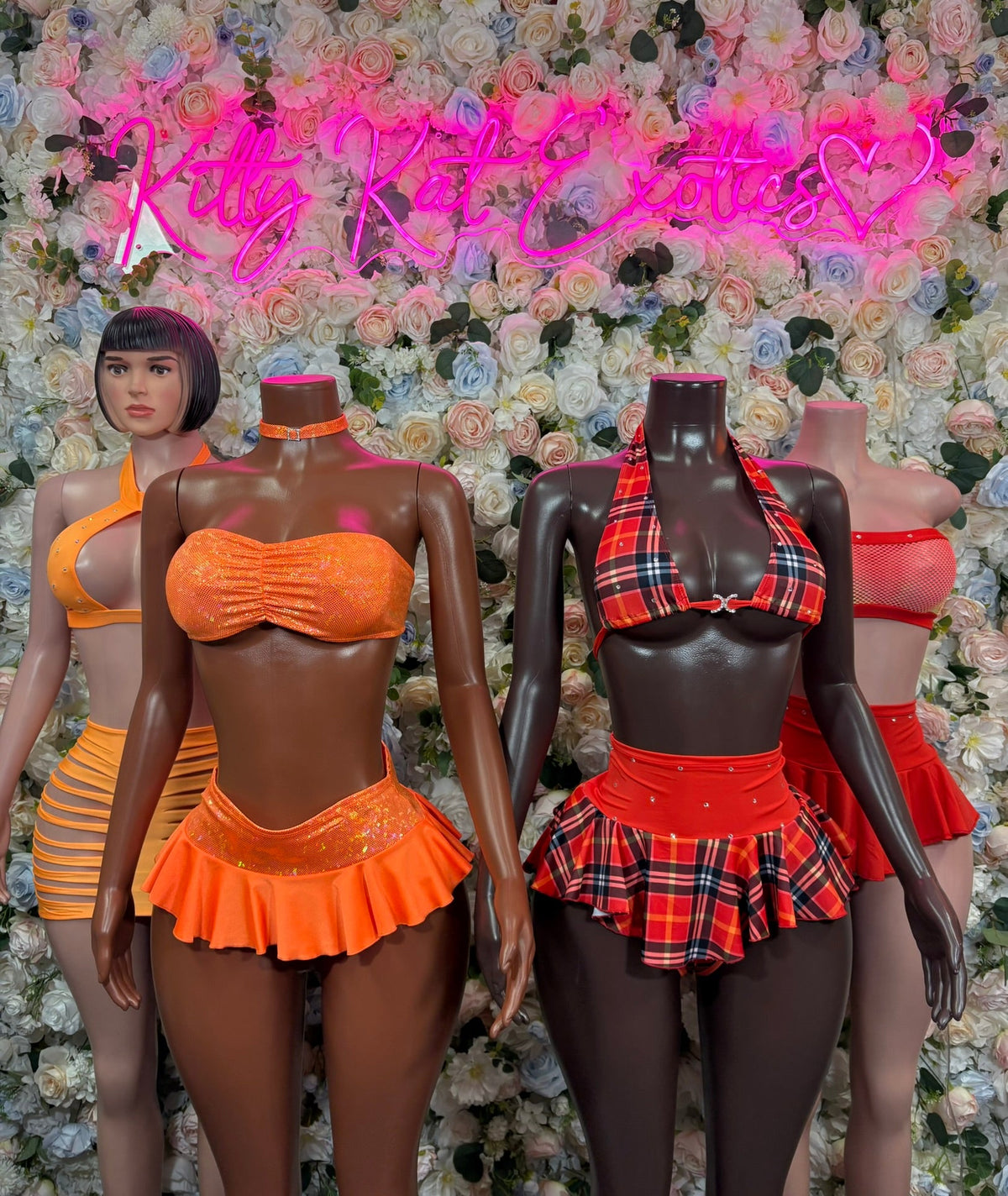Orange ruched bandeau and ruffled mini skirt set on mannequin, front view