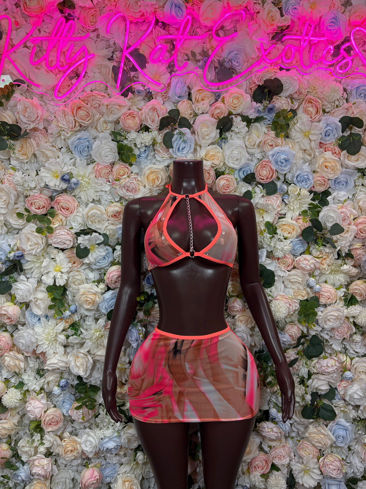Coral strappy halter top with chain detail and printed mesh mini skirt set on mannequin