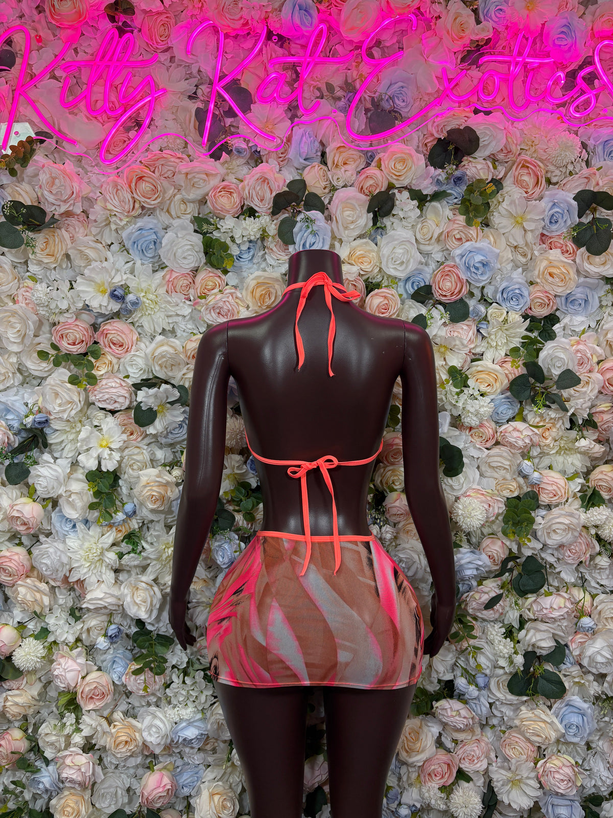Back view of coral halter top with crisscross straps and printed mesh mini skirt set