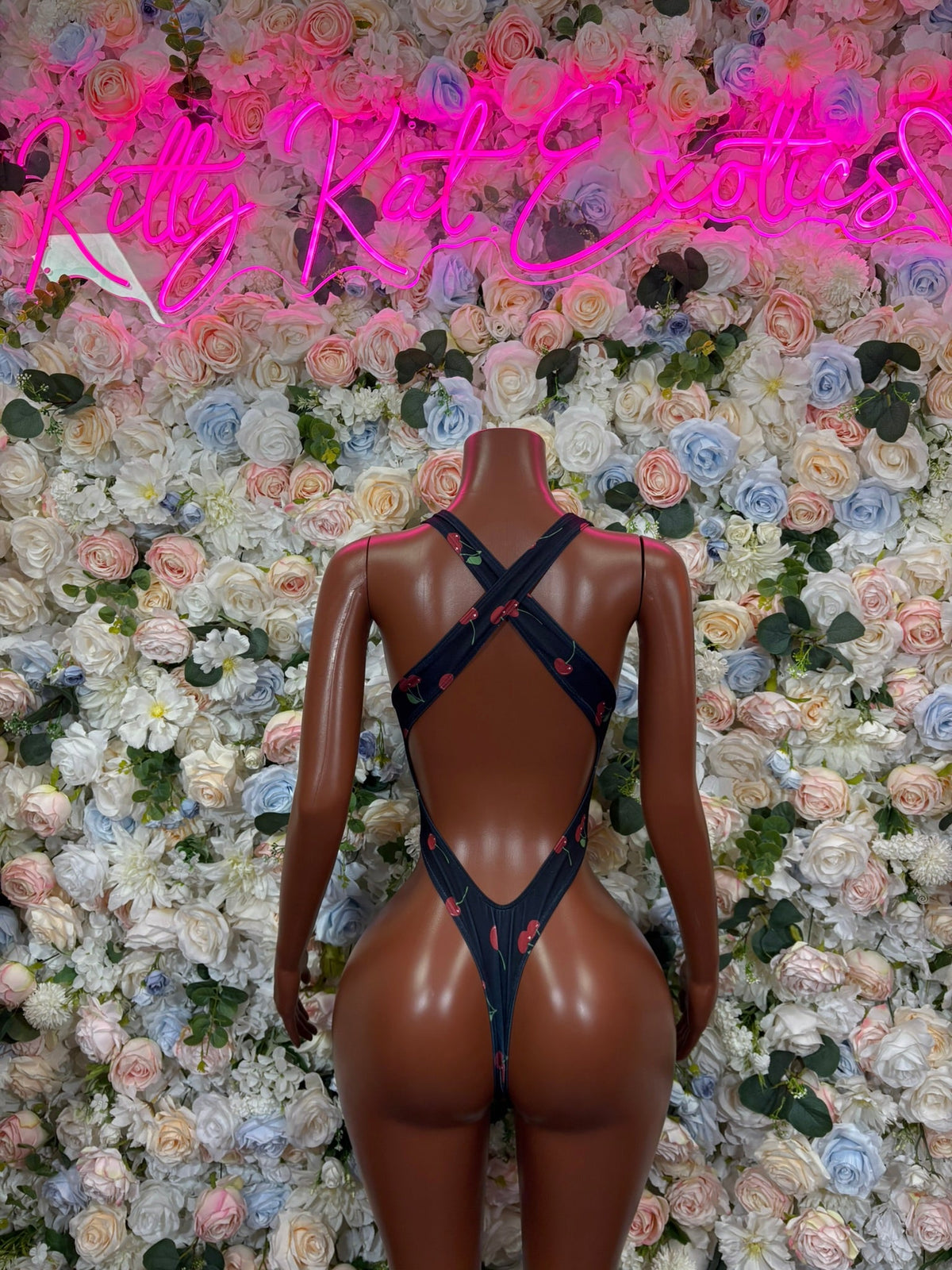 Navy cherry-print cross-back cutout bodysuit on mannequin, open back with cross straps