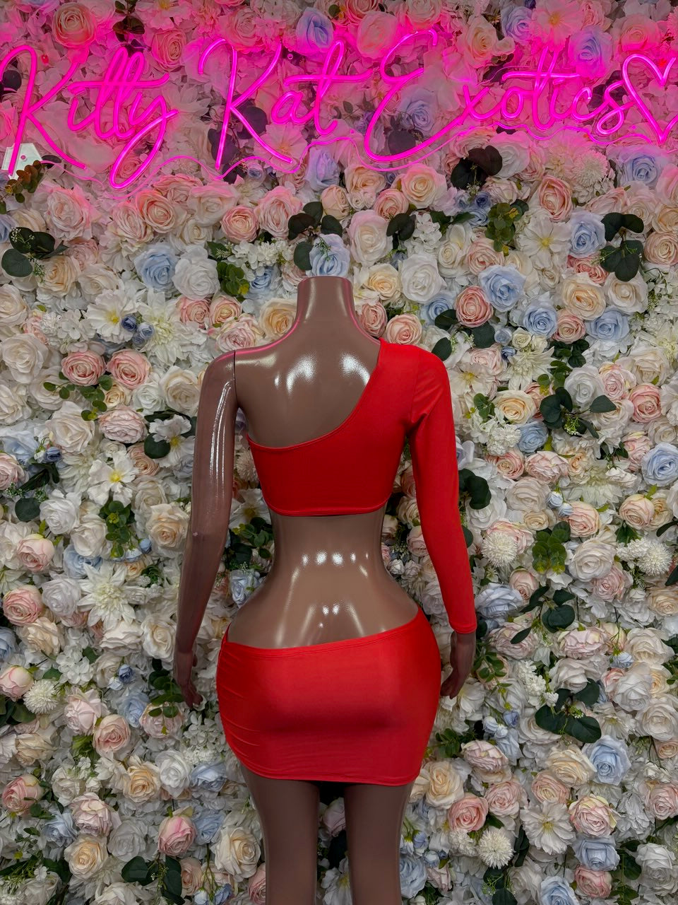 Red one-shoulder cutout crop top and mini skirt set, back on mannequin