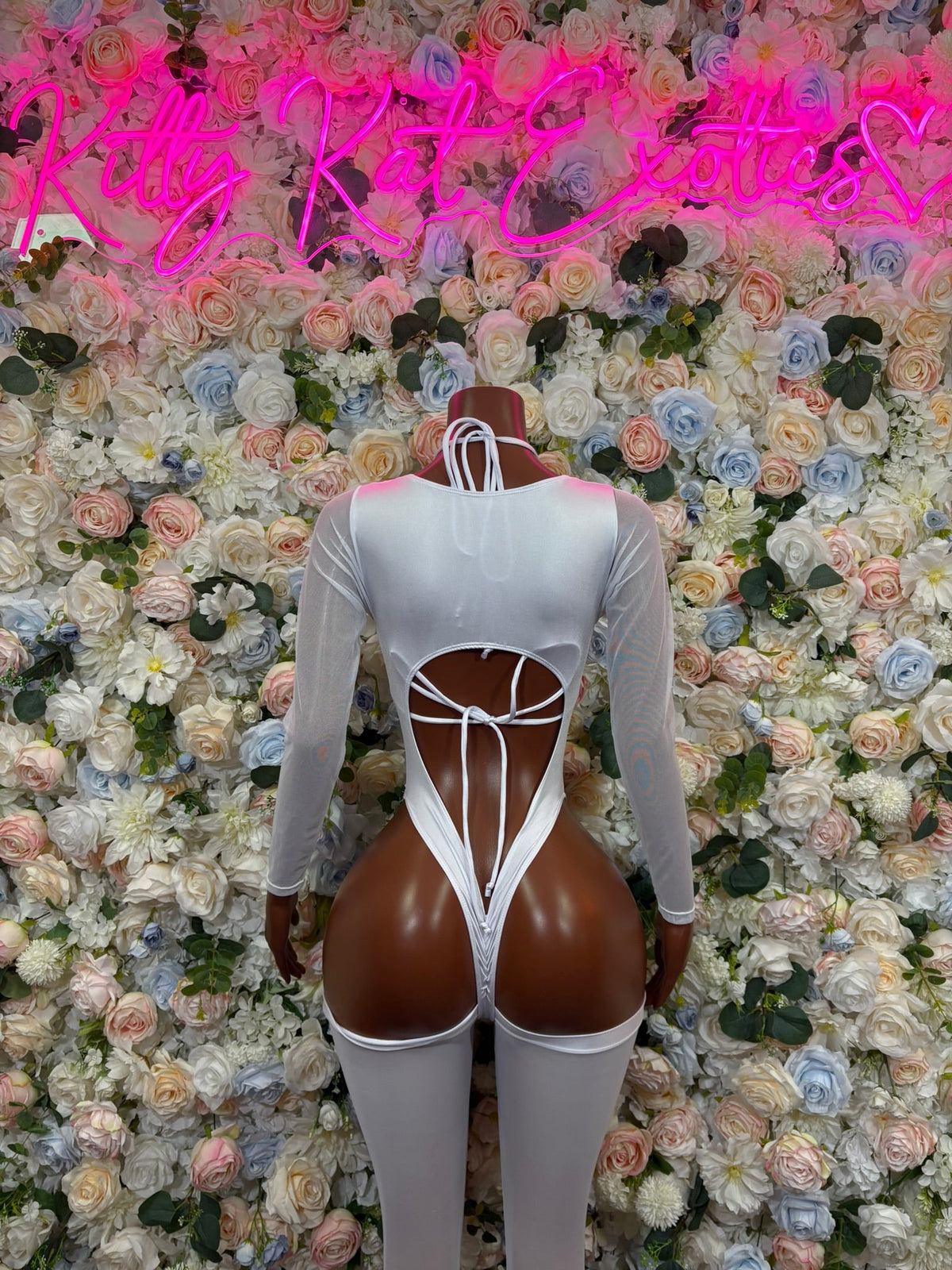 White cutout one-piece bodysuit with long sleeves, large backless center cutout, high leg openings