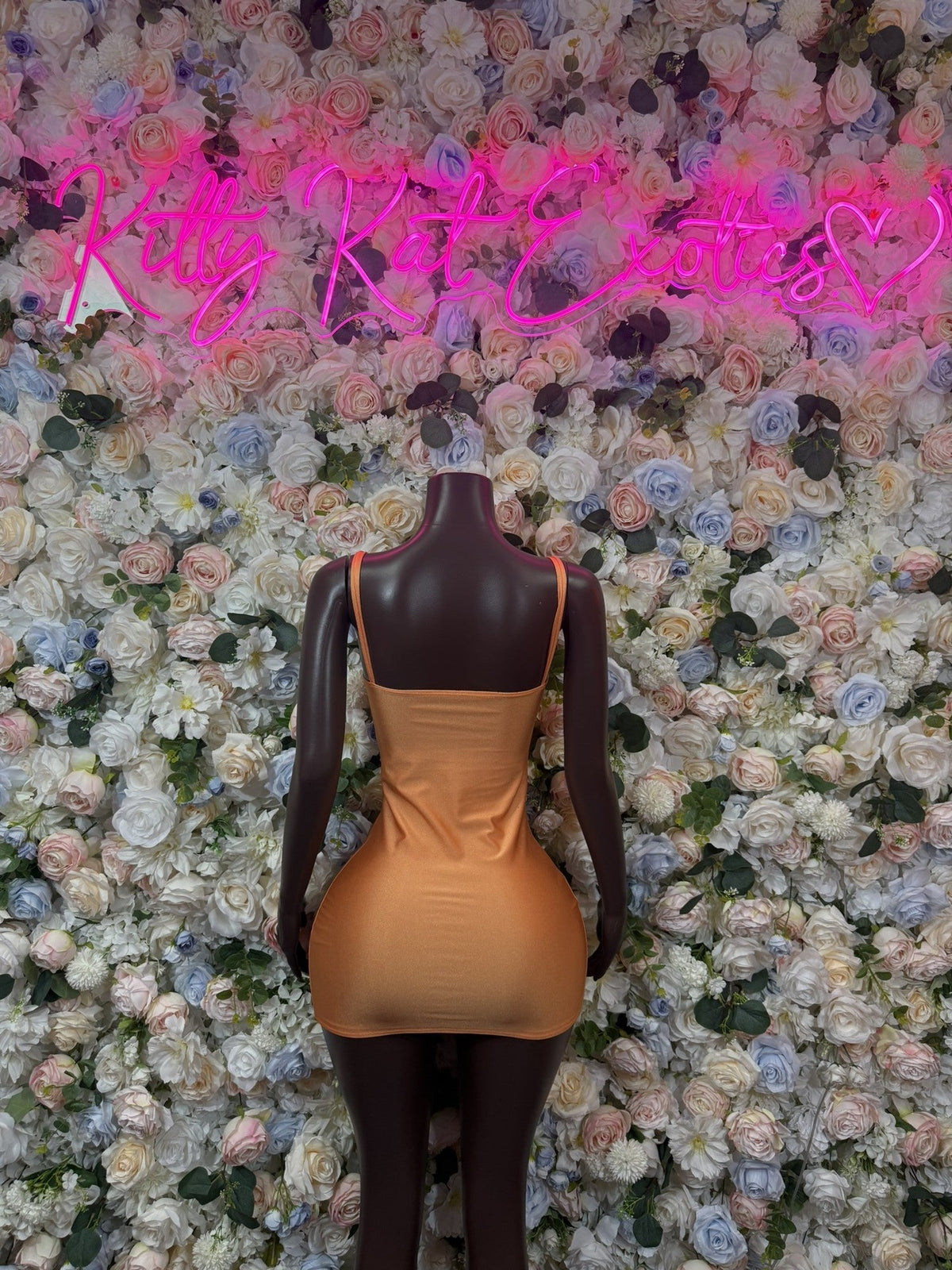 Orange square-neck sleeveless bodycon mini dress on mannequin, fitted silhouette