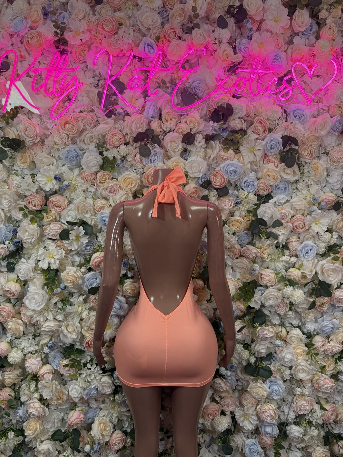 Peach halter plunge bodycon mini dress, fitted silhouette with deep V neckline.